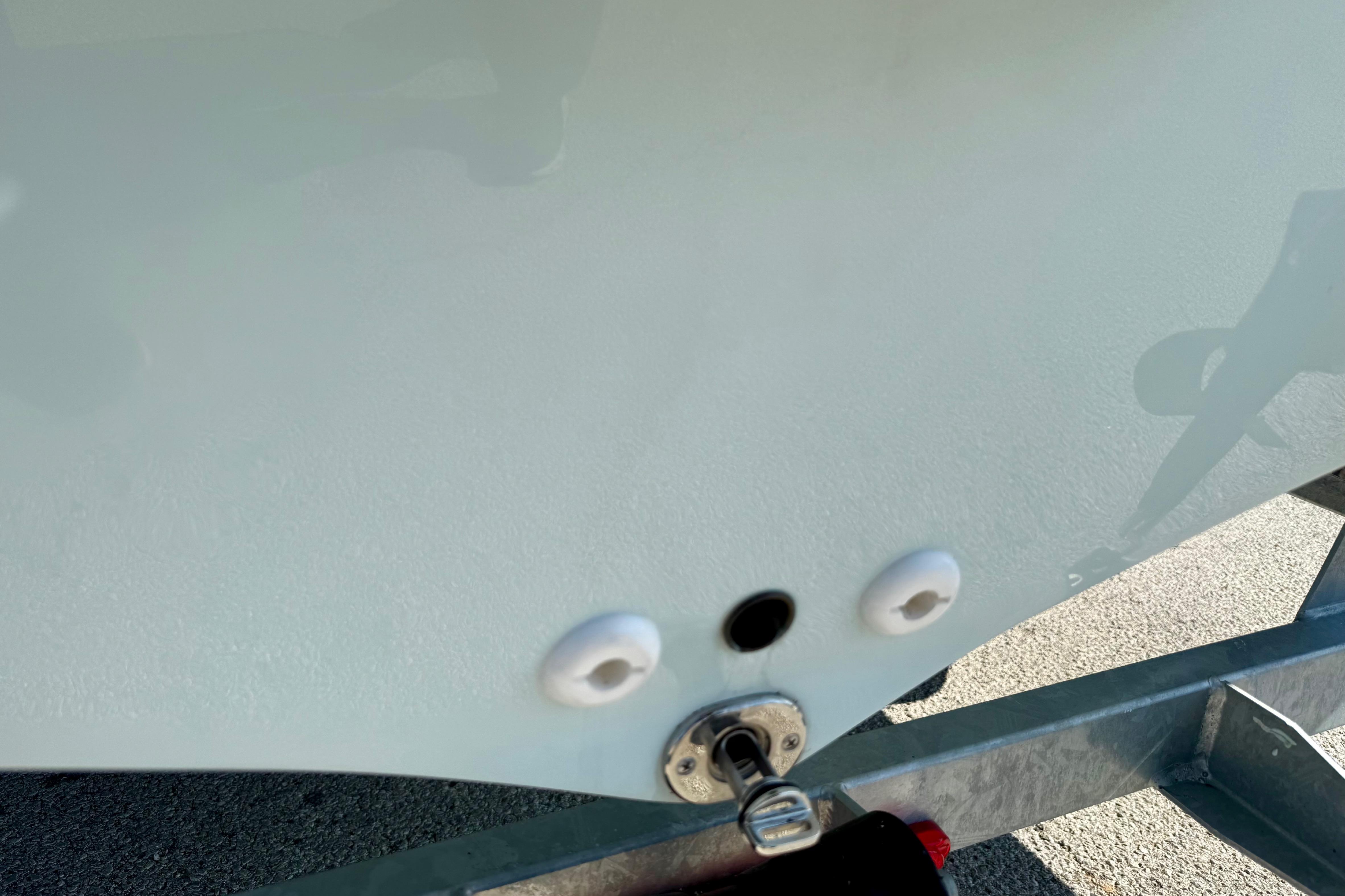 2024 Mako Pro Skiff 19 CC boat hull detail with trailer attachment.