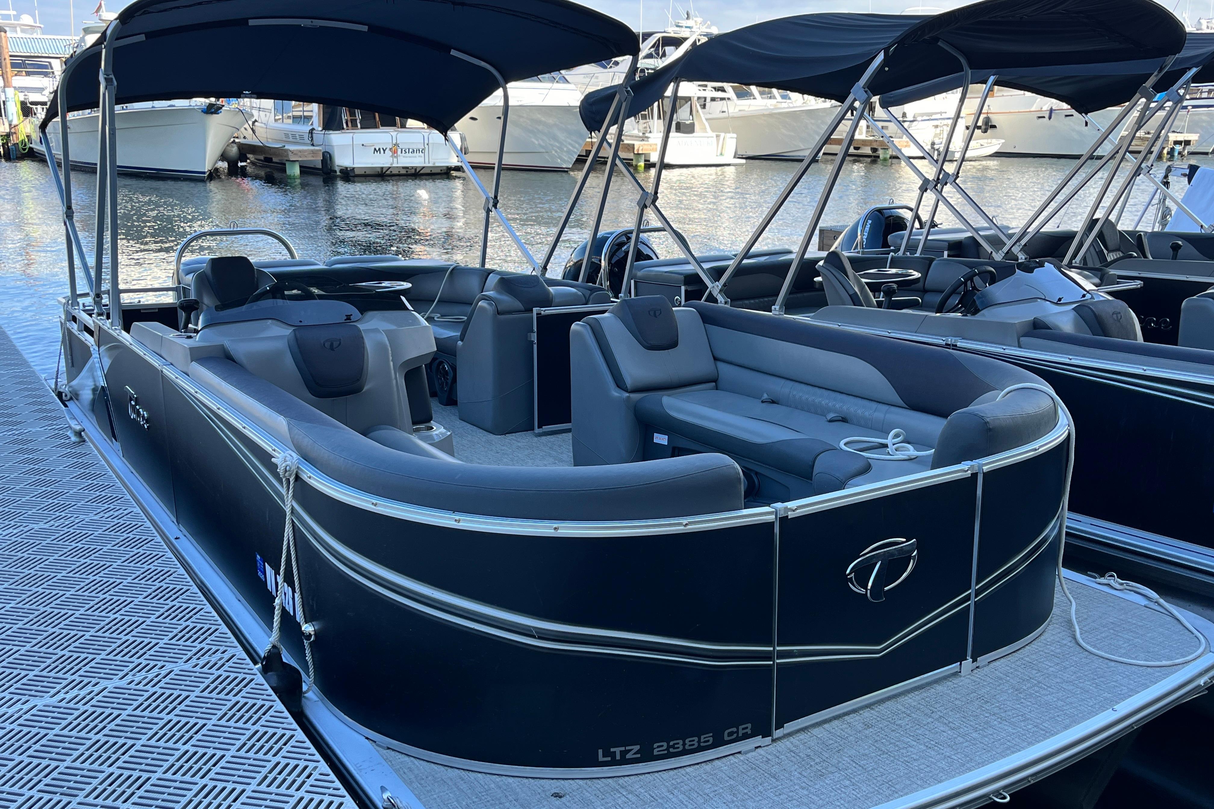 2023 Tahoe Pontoon LTZ Cruise boat docked at marina, featuring sleek design and spacious seating.