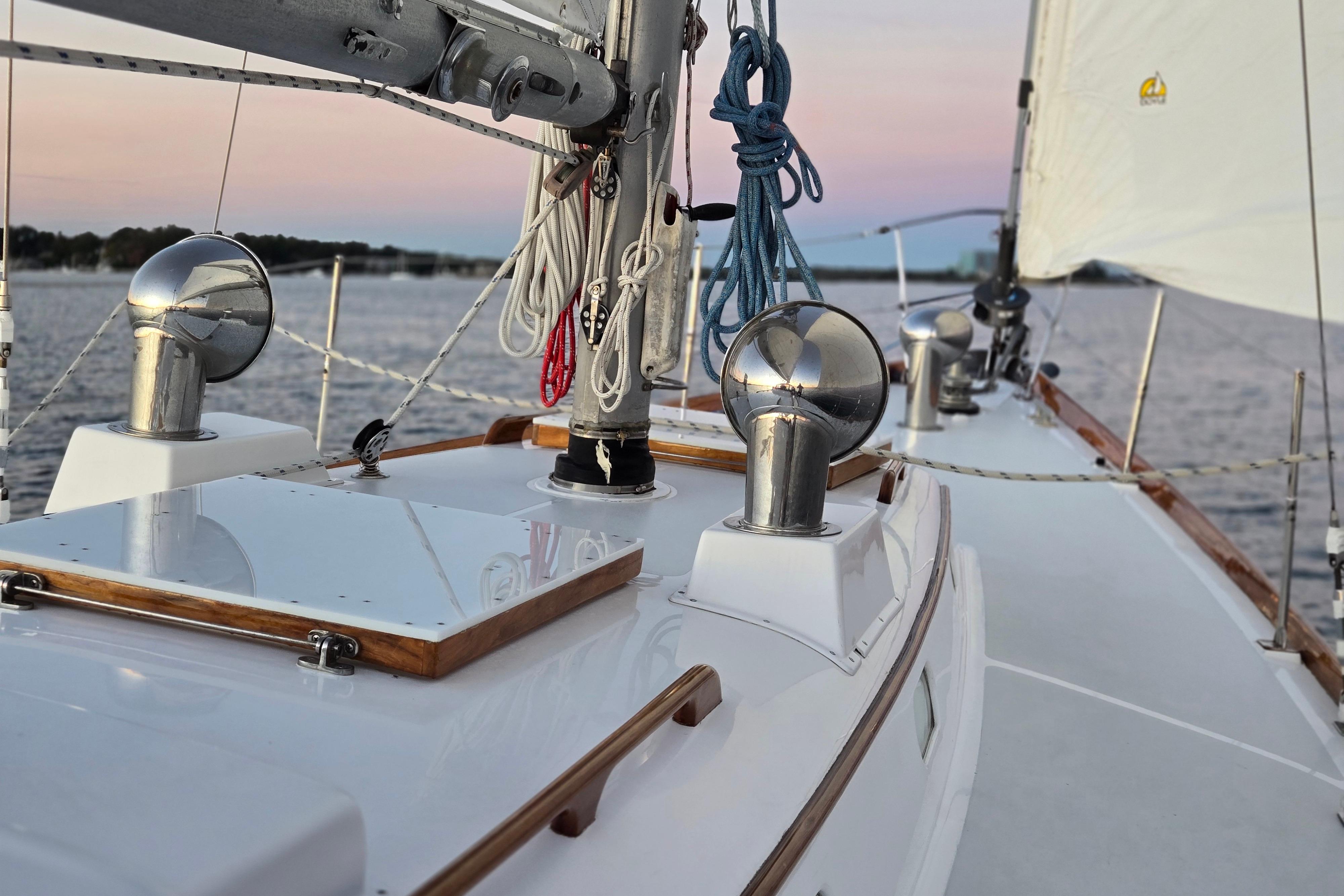 1970 Hinckley Bermuda 40 sailboat deck with ropes and fittings at sunset.