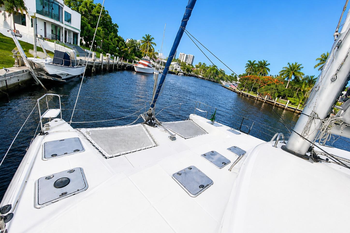 Front deck view of 2010 Lagoon 421 catamaran docked in a scenic canal.