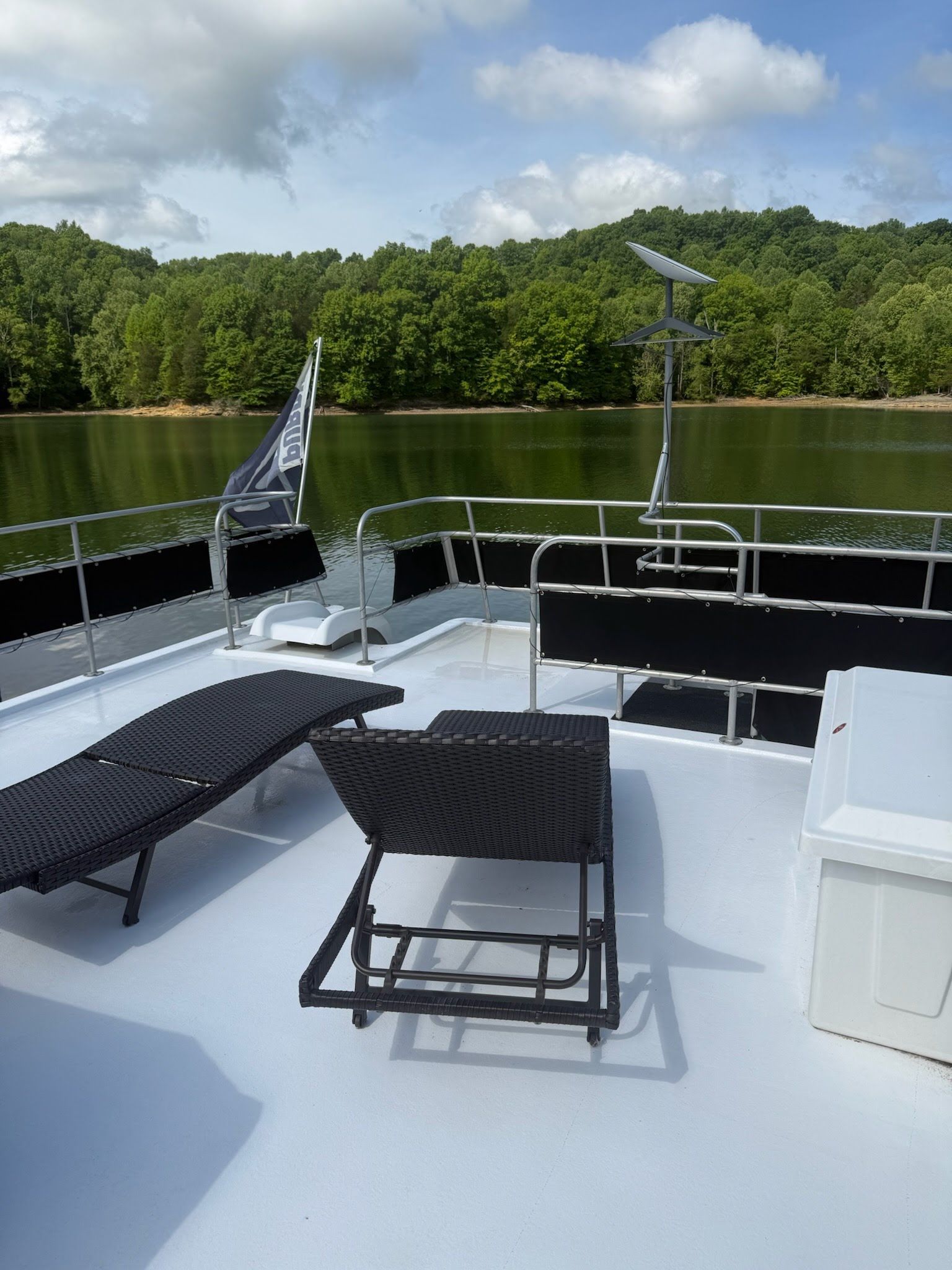 Deck of a 2003 Lakeview 16x70 houseboat with lounge chairs.