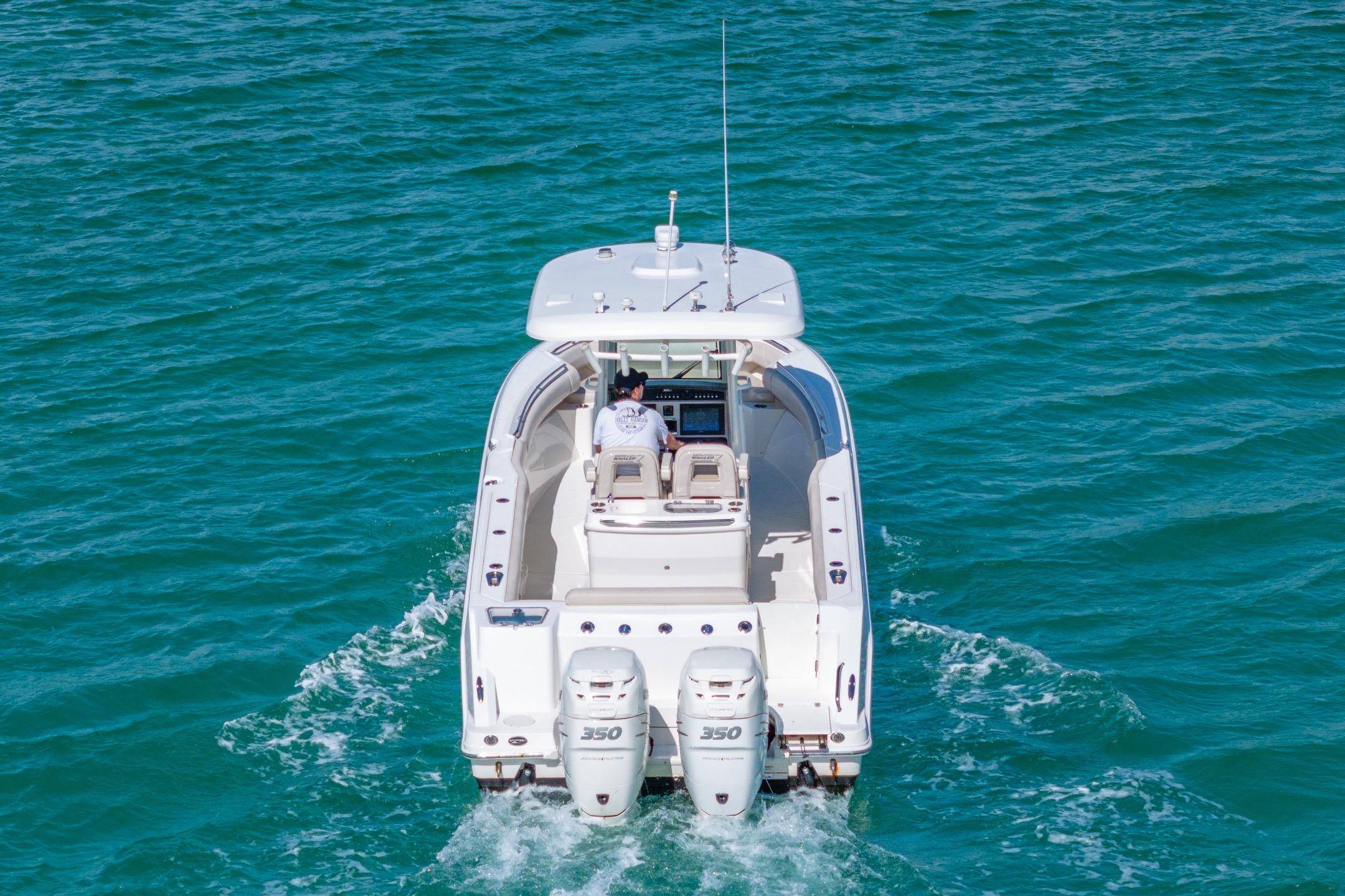 2016 Boston Whaler 280 Outrage cruising on open water, rear view.