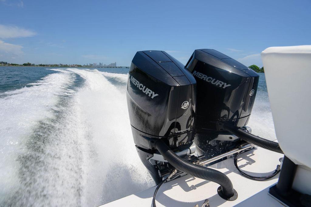 Twin Mercury outboard engines powering a 2027 Reef Runner 340 boat on open water.