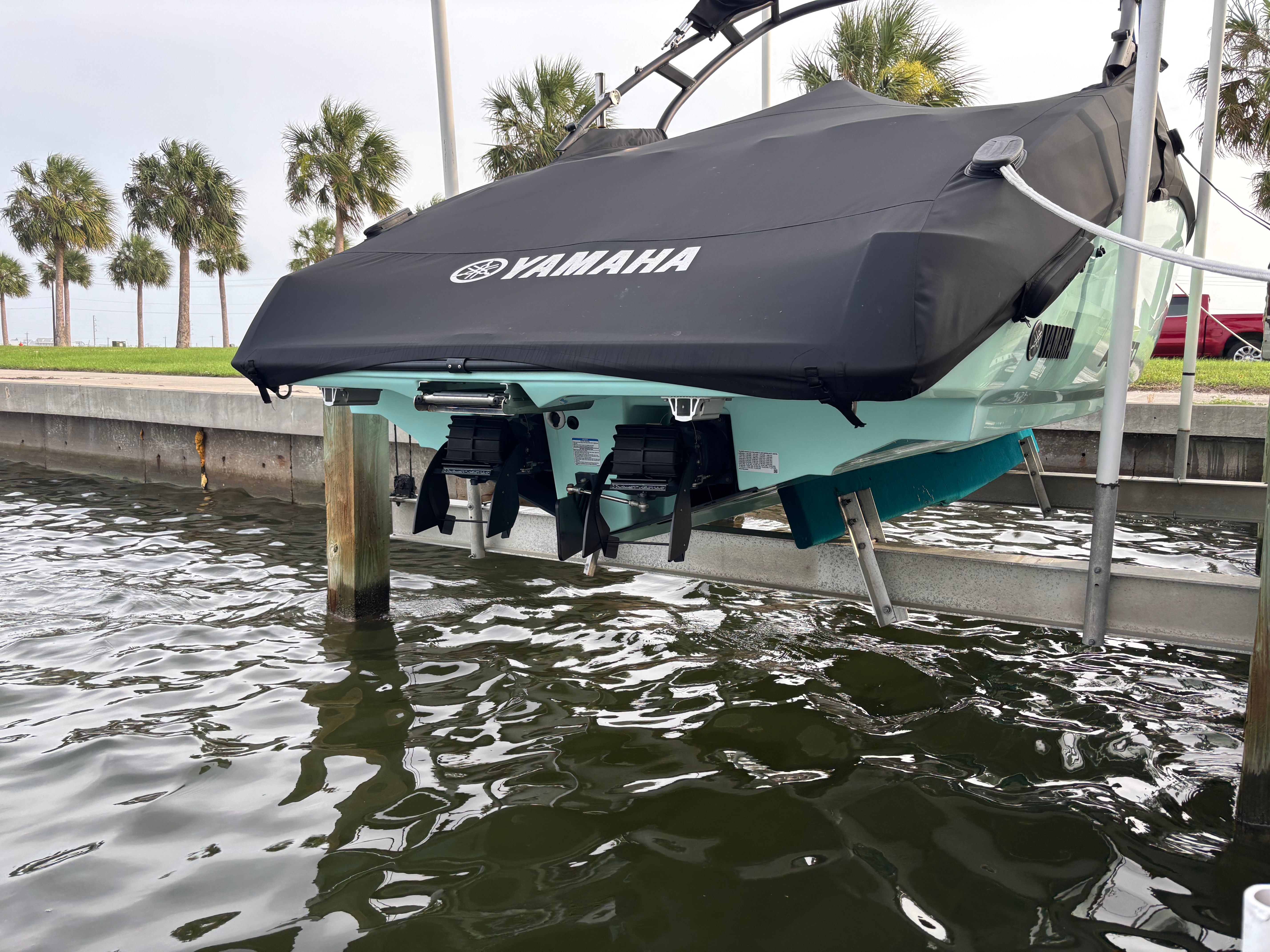 A 2024 Yamaha AR250 boat on a lift above the water.