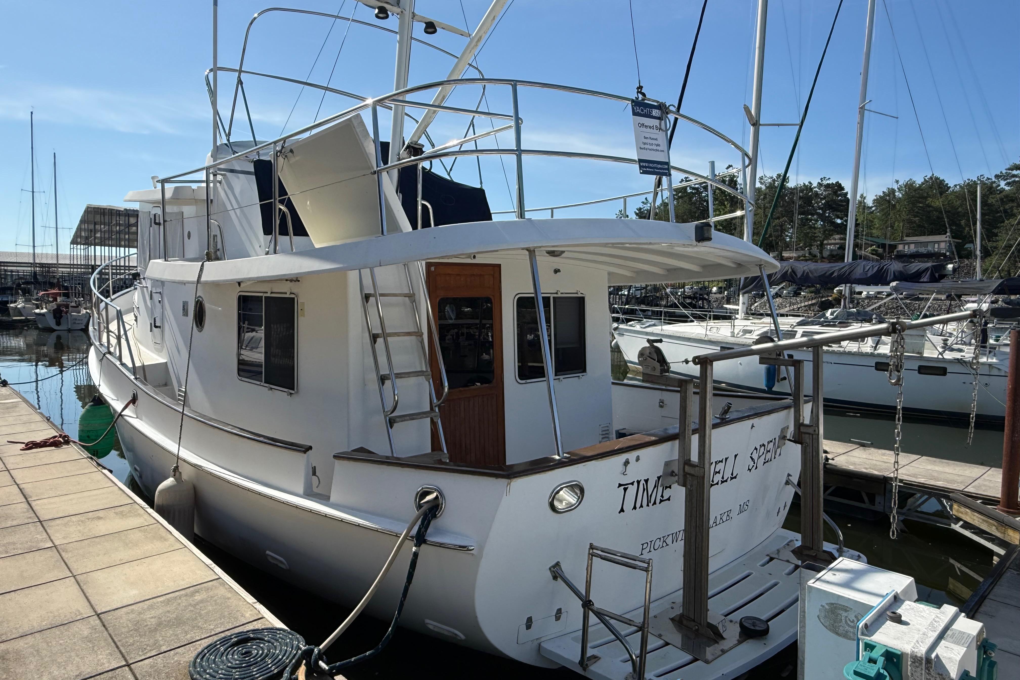 Kadey-Krogen 39 yacht, 2001 model, docked at a marina under clear blue skies.
