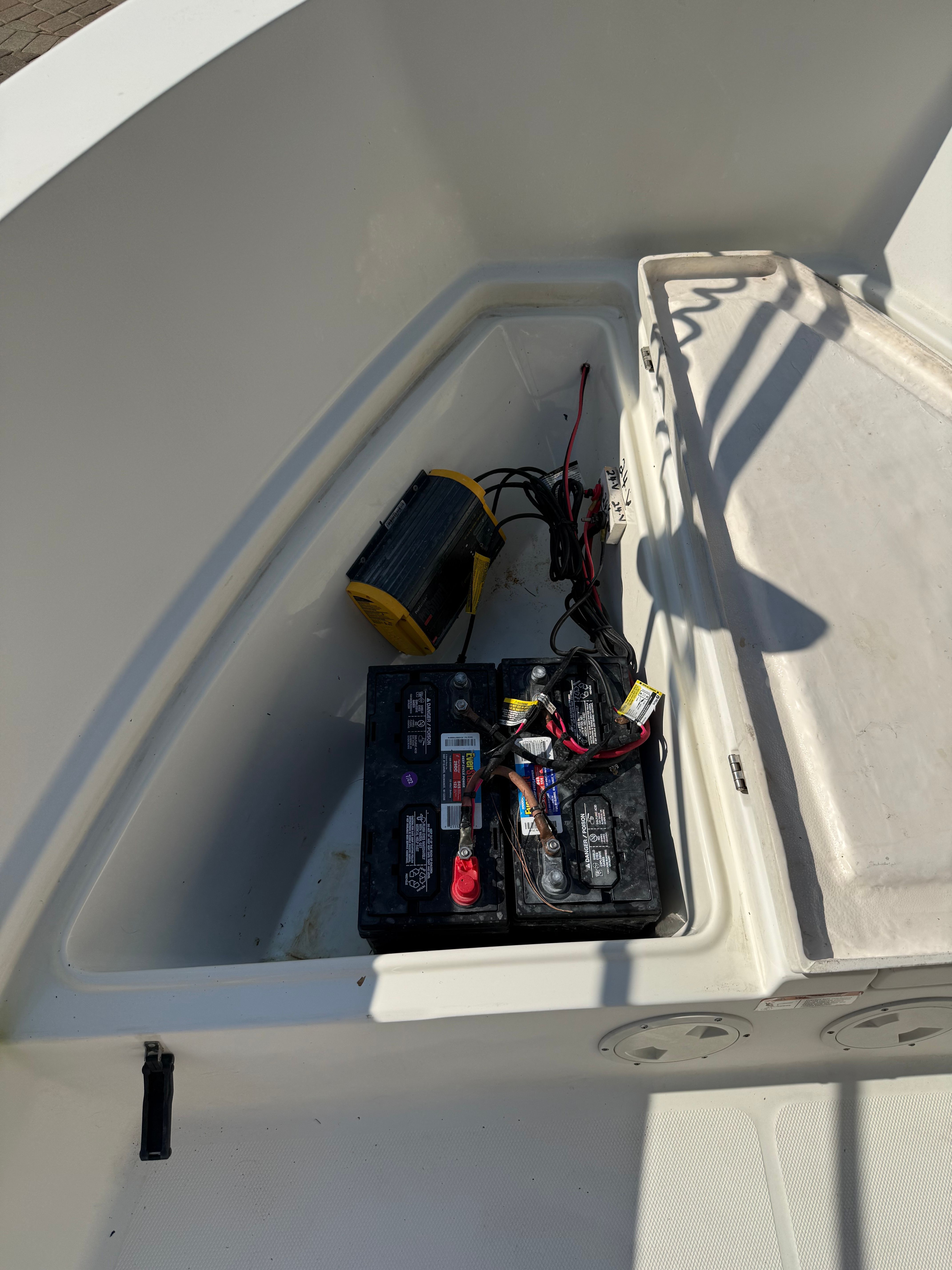 Batteries and cables in a boat storage compartment.