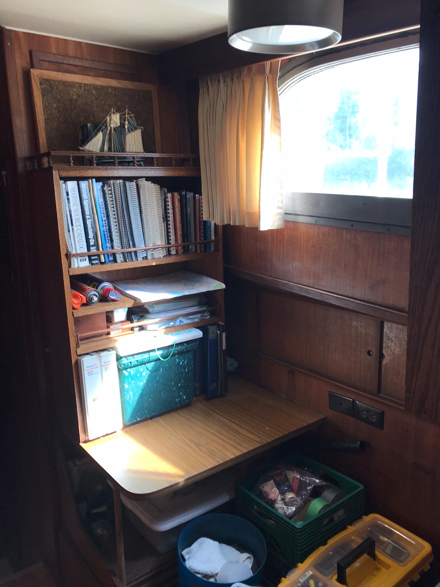 1978 Hatteras 58 MY interior with wooden desk, shelves, and window.