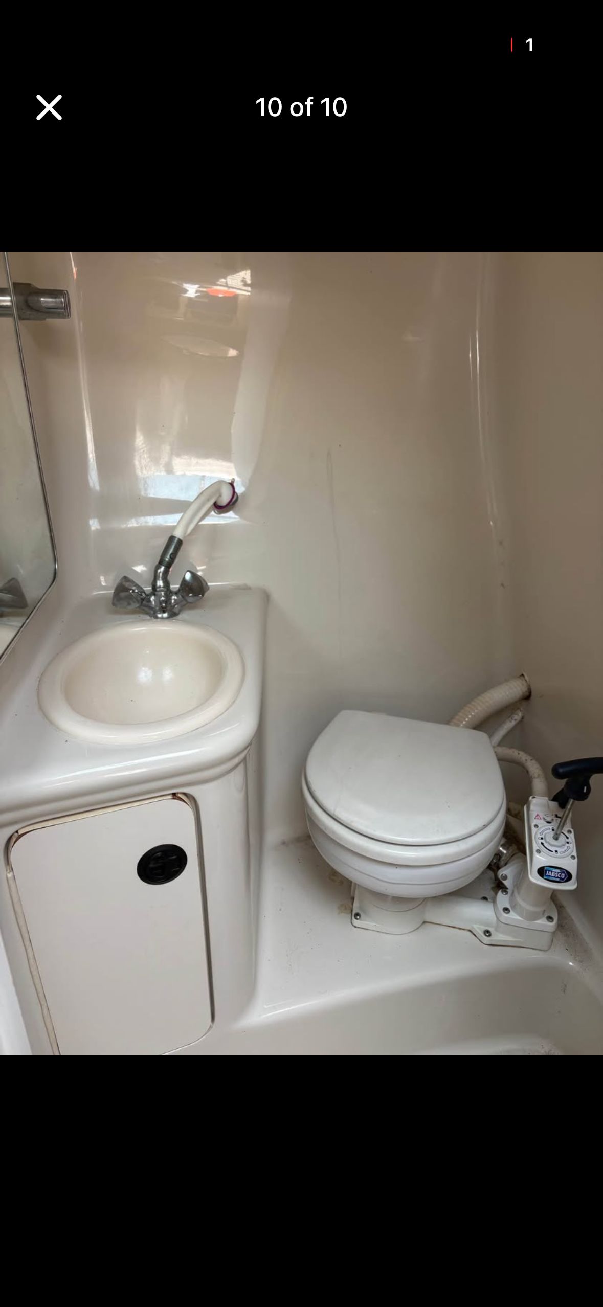 The image shows a bathroom with a sink and toilet inside a boat.