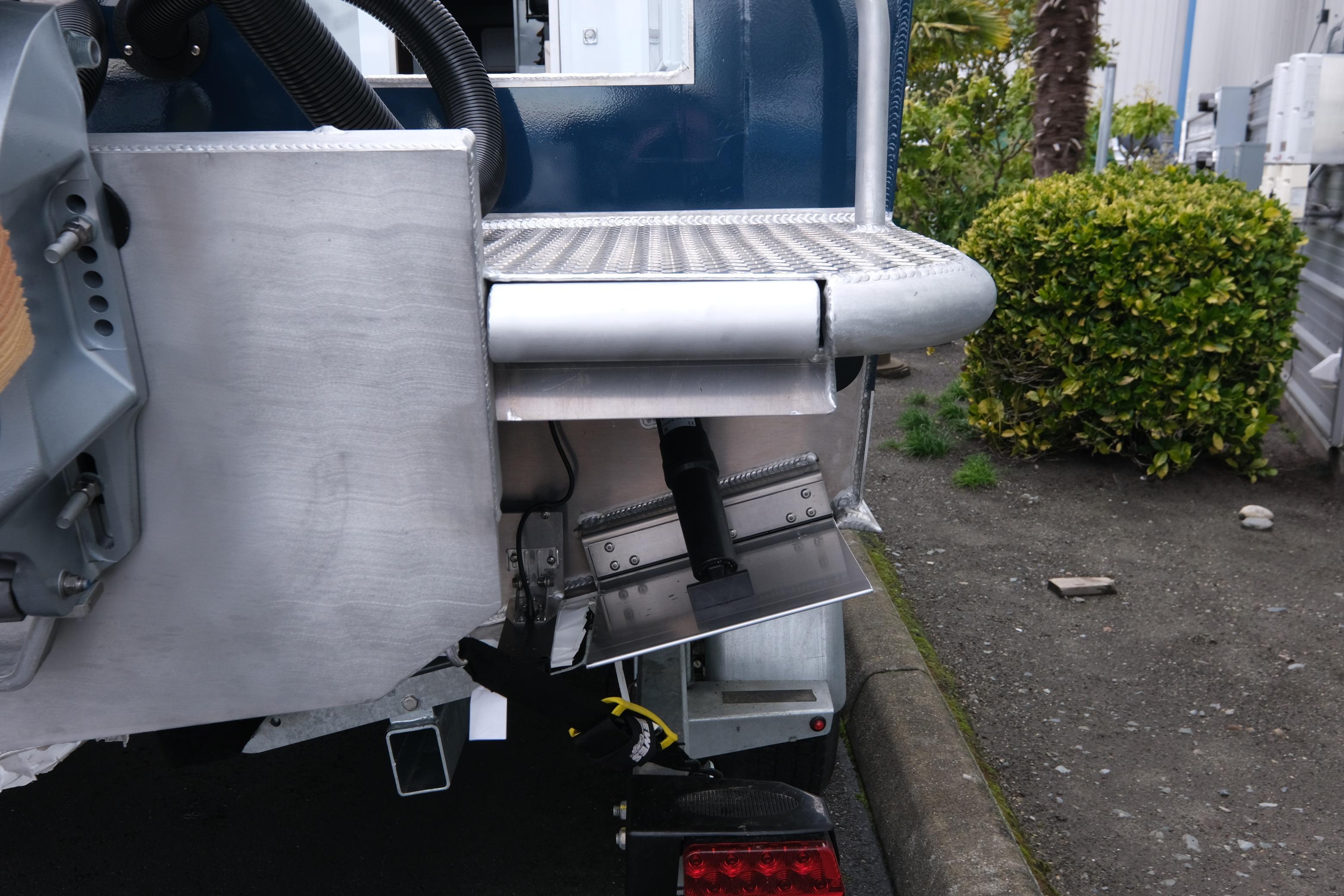 Rear view of 2026 Hewescraft 270 Pacific Explorer boat with trim tab and metal platform.