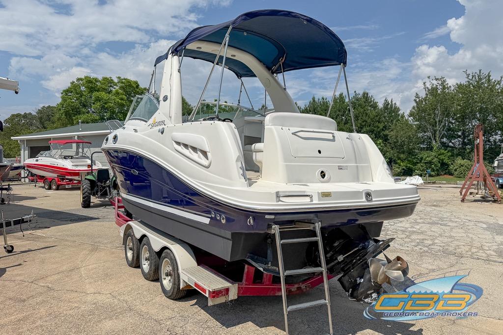 2006 Sea Ray Sundancer 260 boat on trailer, blue and white, parked outdoors.