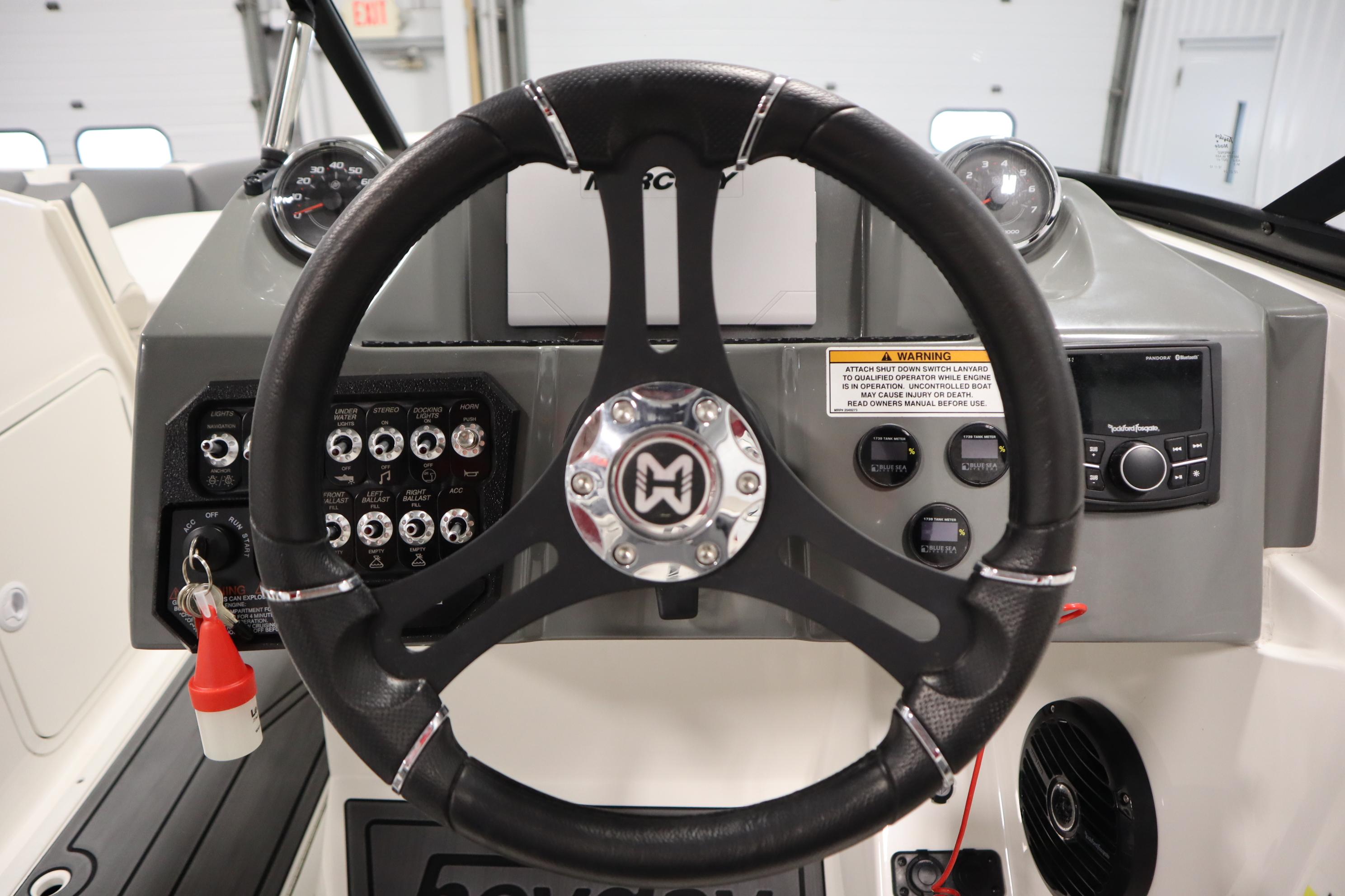 2023 Heyday WT Surf boat dashboard with steering wheel and control panel.