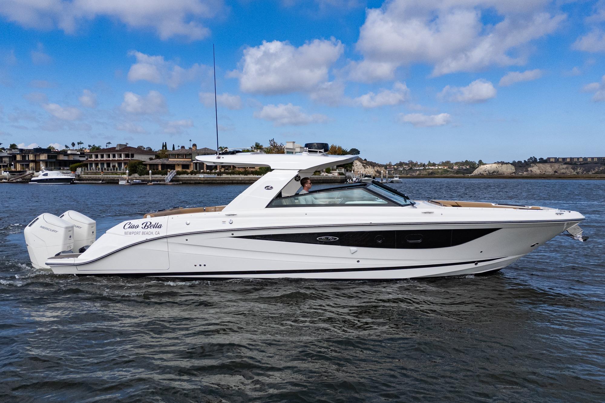 2023 Sea Ray SLX 400 Outboard cruising on water, Newport Beach backdrop.