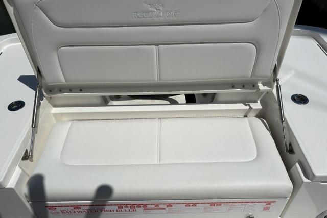 2024 Regulator 24XO boat seat with storage compartment open, showcasing white cushioned seating.