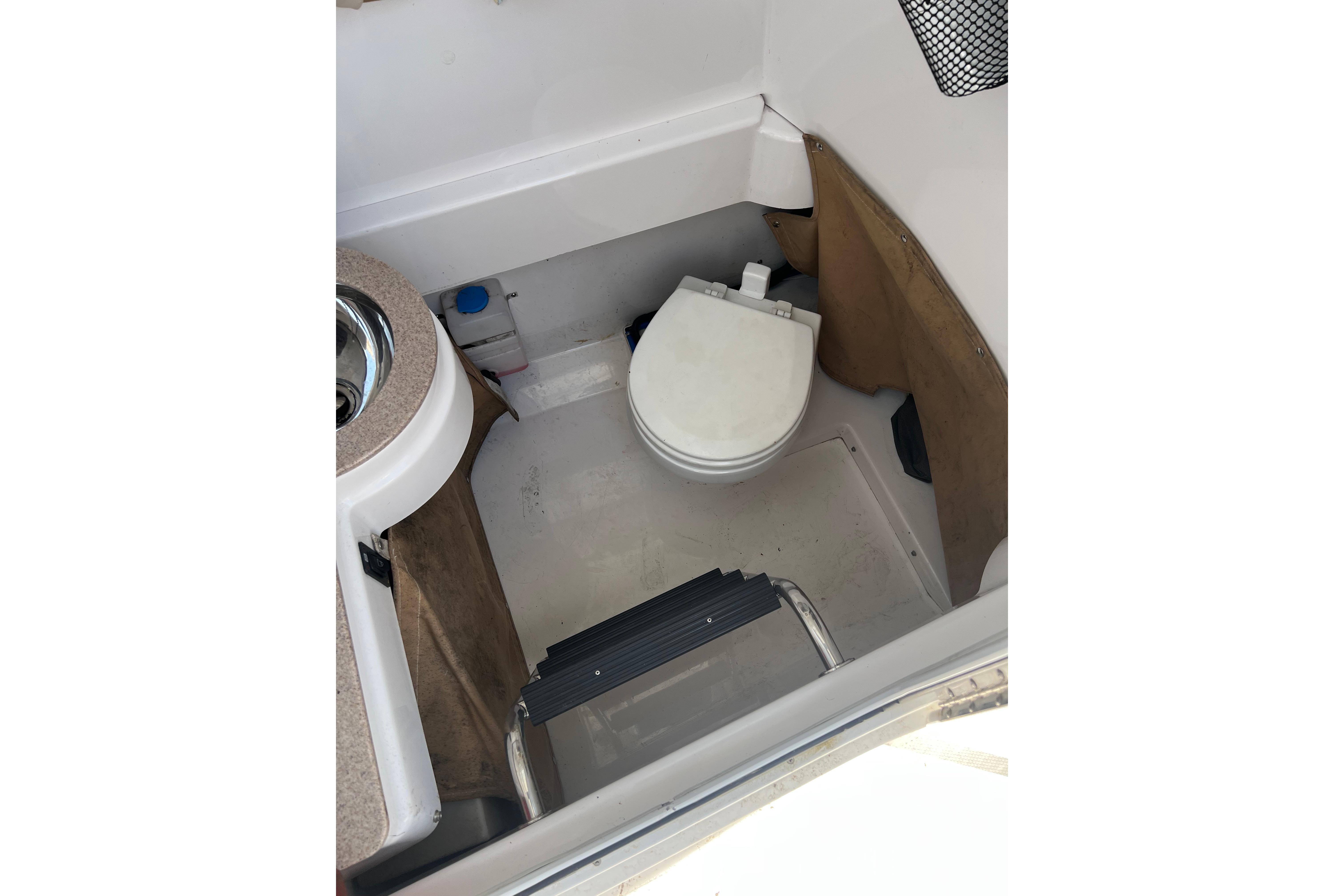 Interior of 2006 Southport 26 Center Console boat with compact marine toilet.