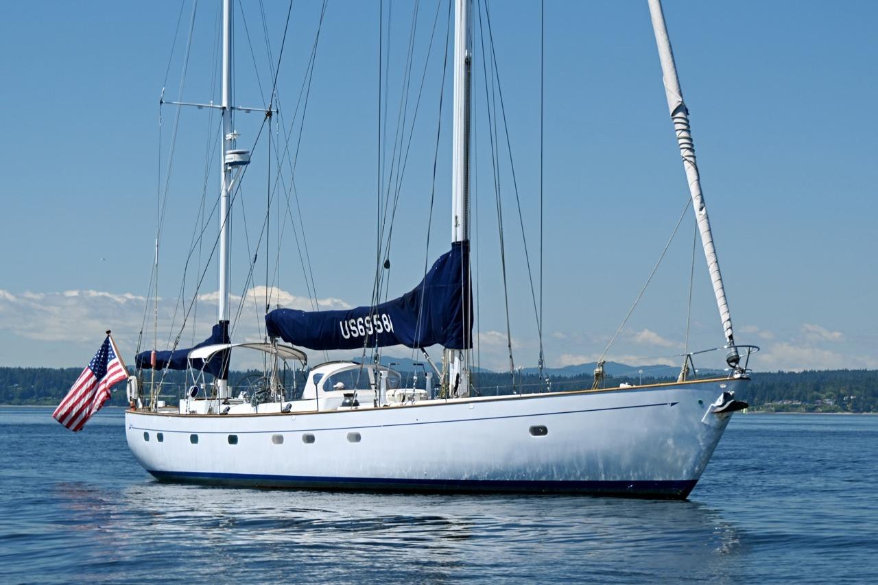Sailing yacht Abeking & Rasmussen Tripp 74, 1968, on calm waters with American flag.