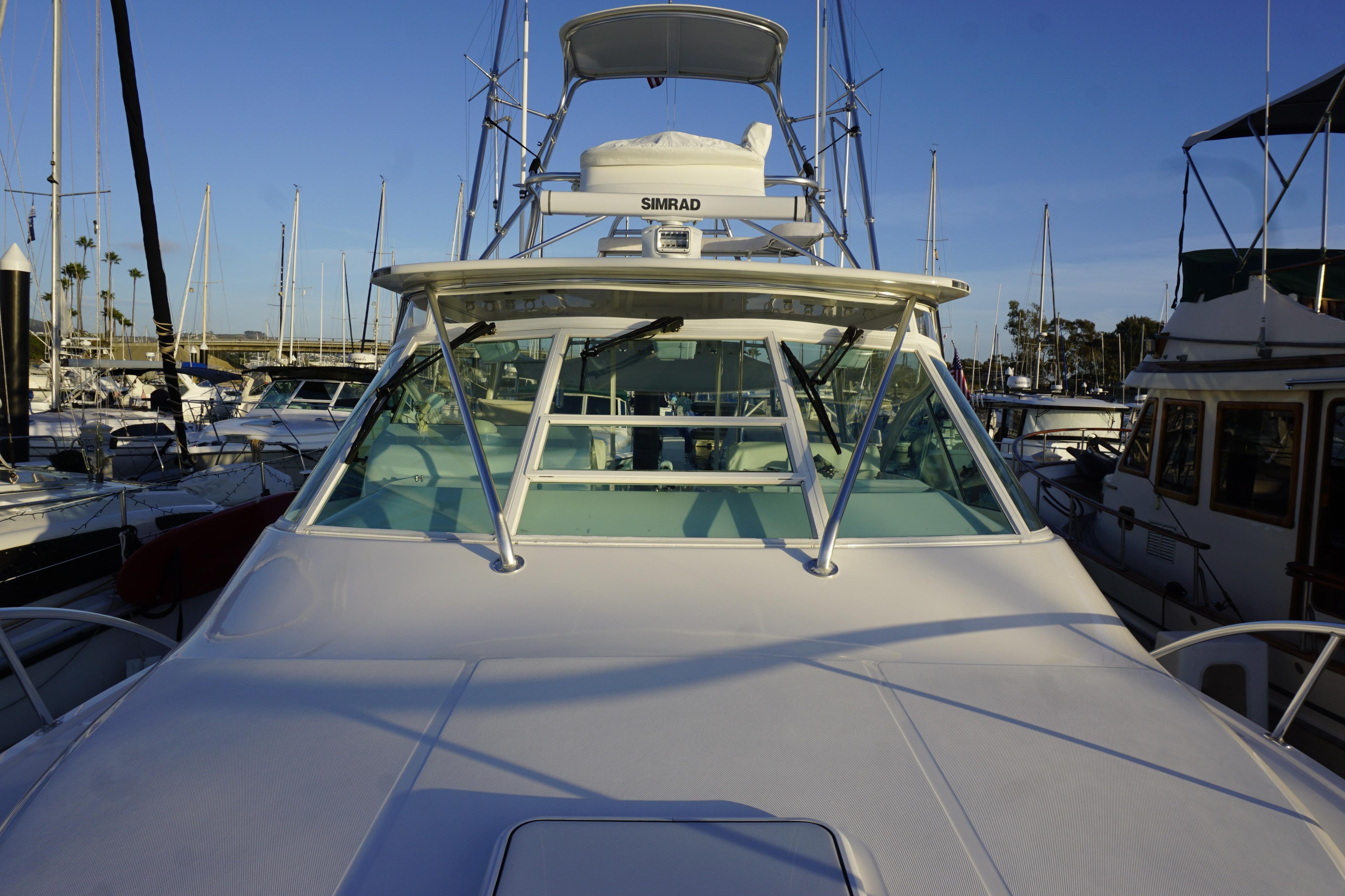 2005 Cabo 35 Express boat docked in marina, surrounded by other vessels.