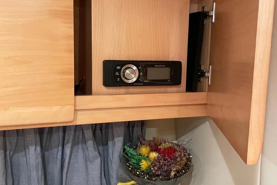 Wooden cabinet with stereo system in 2007 Fiart 34 Genius boat interior.