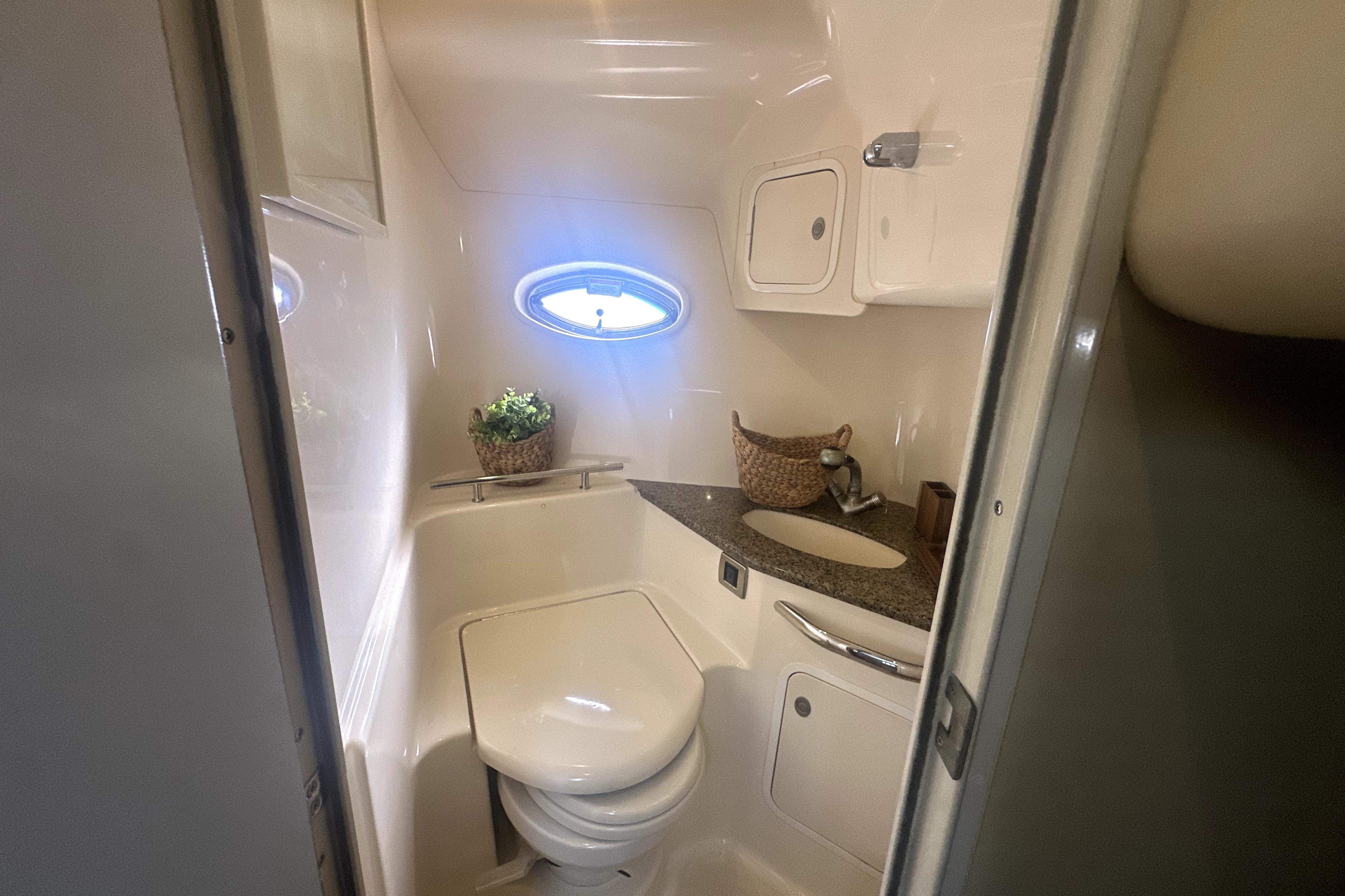 2007 Sea Ray 44 Sundancer bathroom with modern fixtures and porthole window.