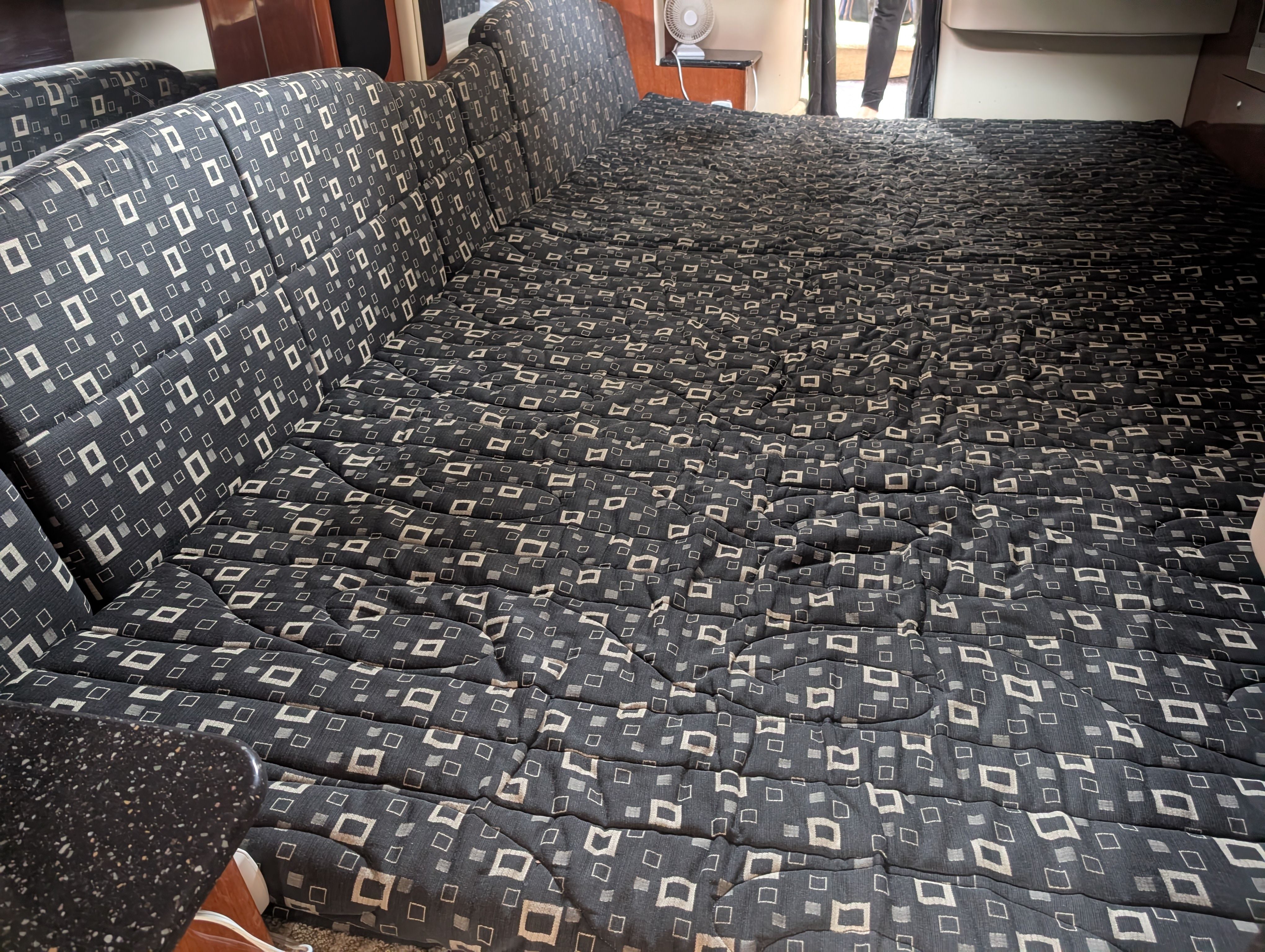 Interior with patterned upholstery, likely a sleeping or seating area.