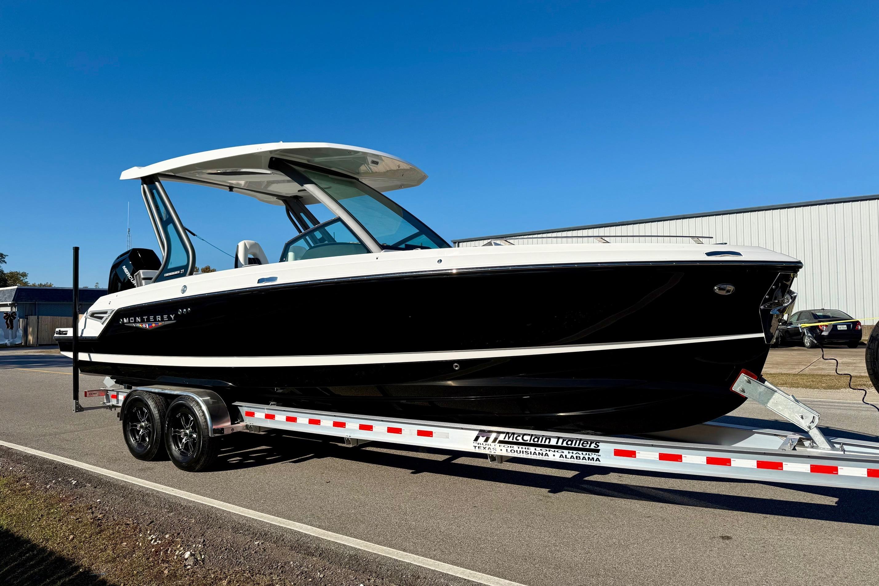 2026 Monterey Elite 27 OB boat on trailer, side view.