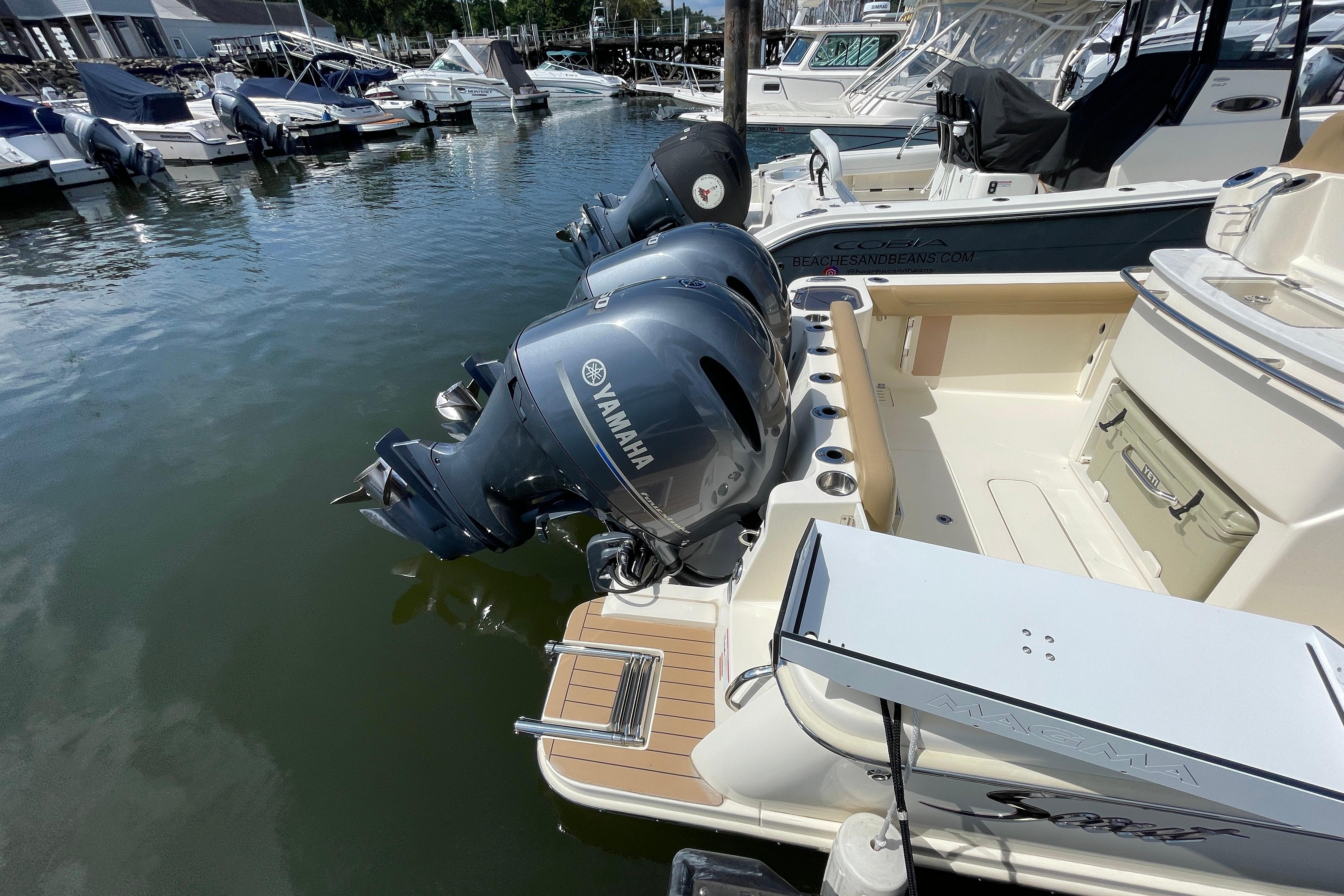 2020 Scout 255 LXF boat with Yamaha engines docked at a marina.