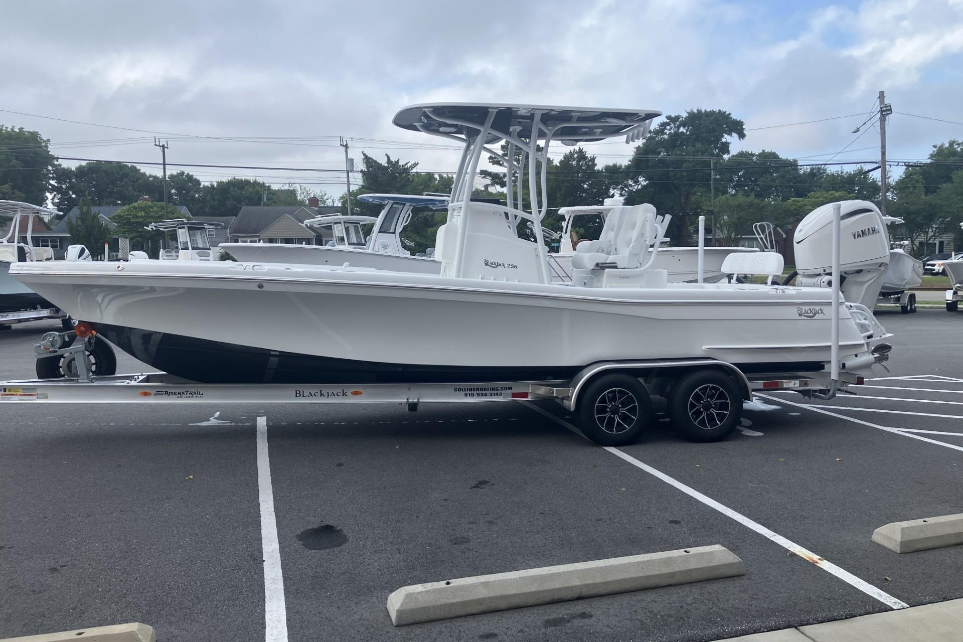 2026 BlackJack 256 Coastal boat on trailer in parking lot.