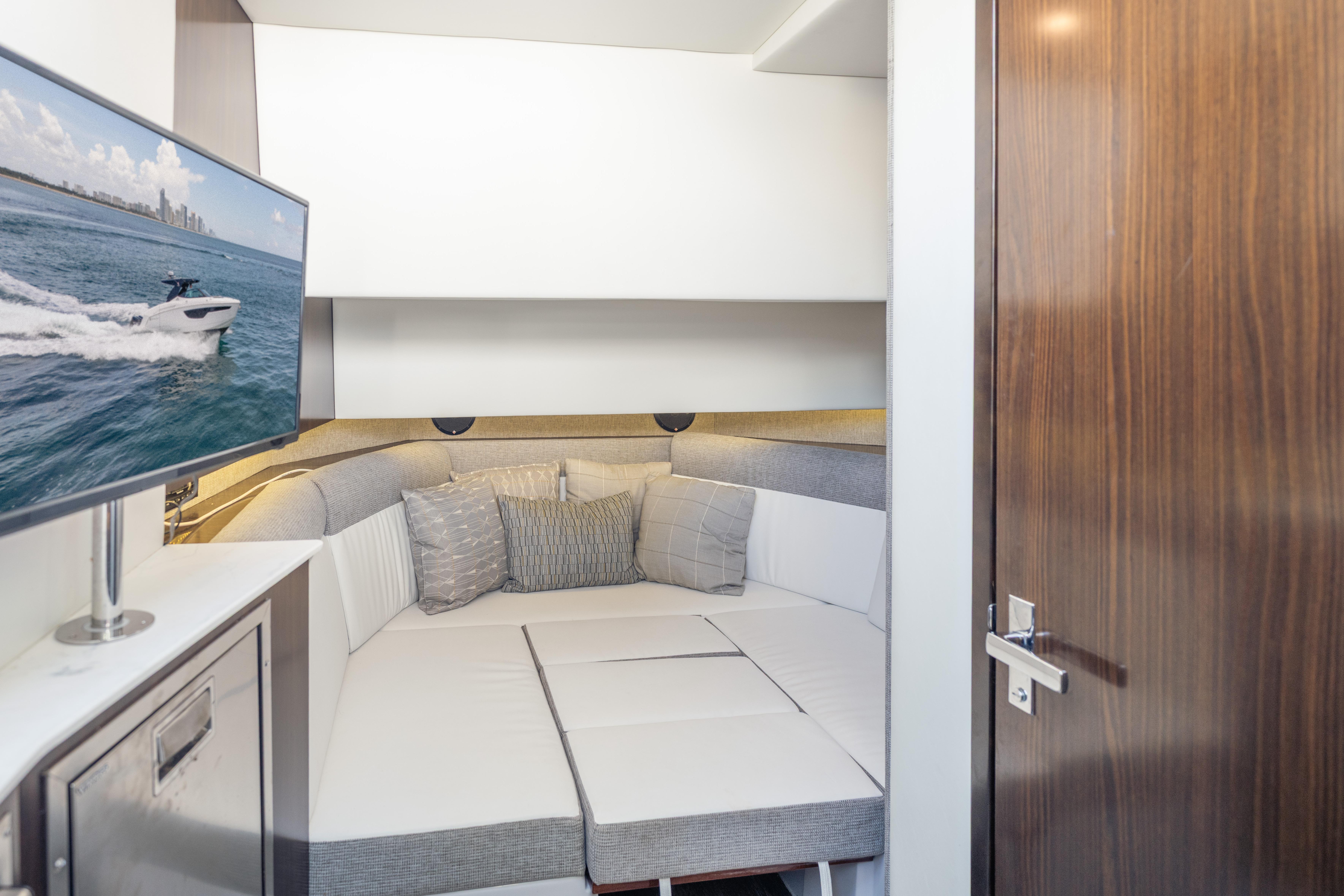 Interior of 2021 Cruisers Yachts 38 GLS with cozy seating and mounted TV.