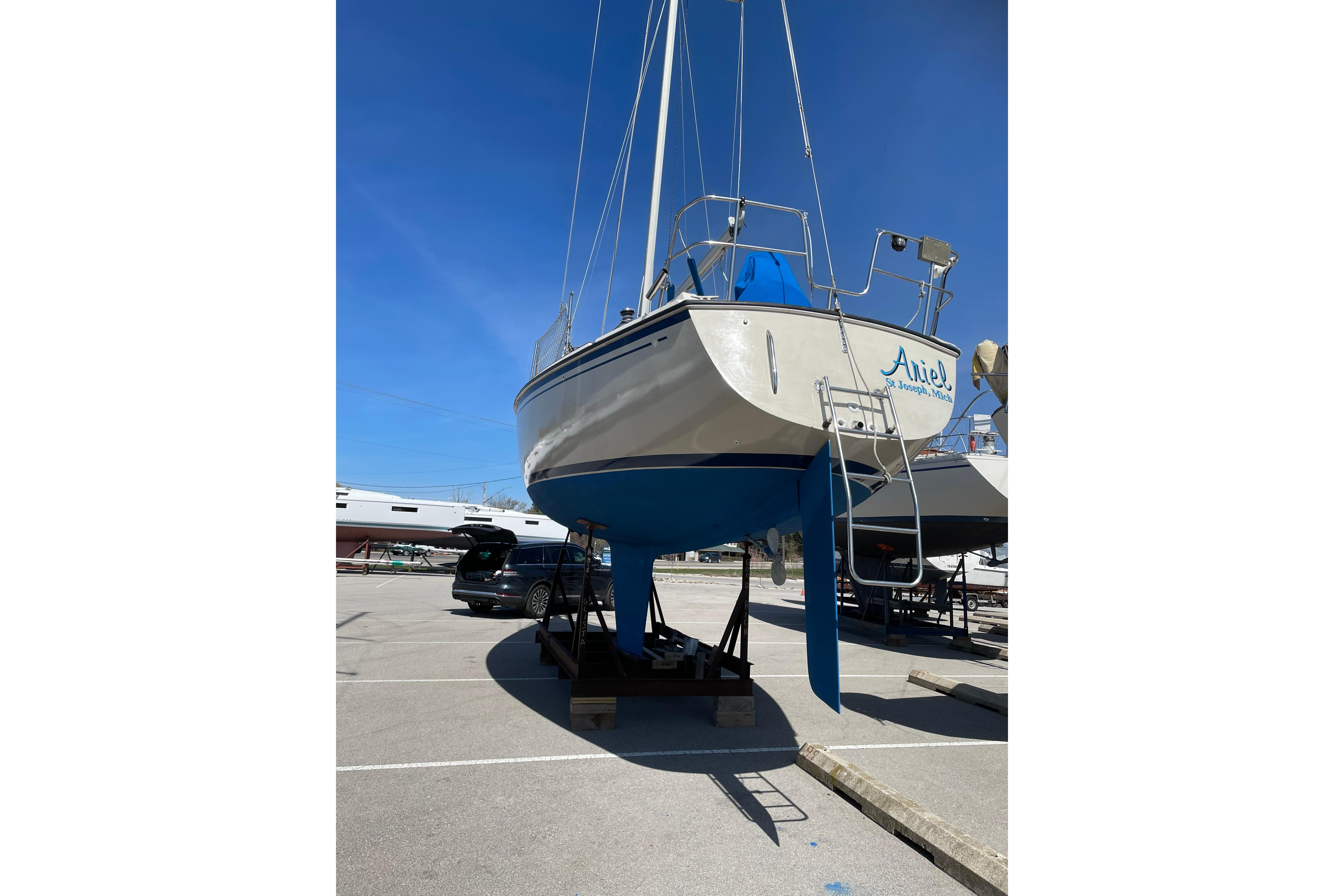 1983 O'Day 34 sailboat on stands in a marina, clear blue sky.