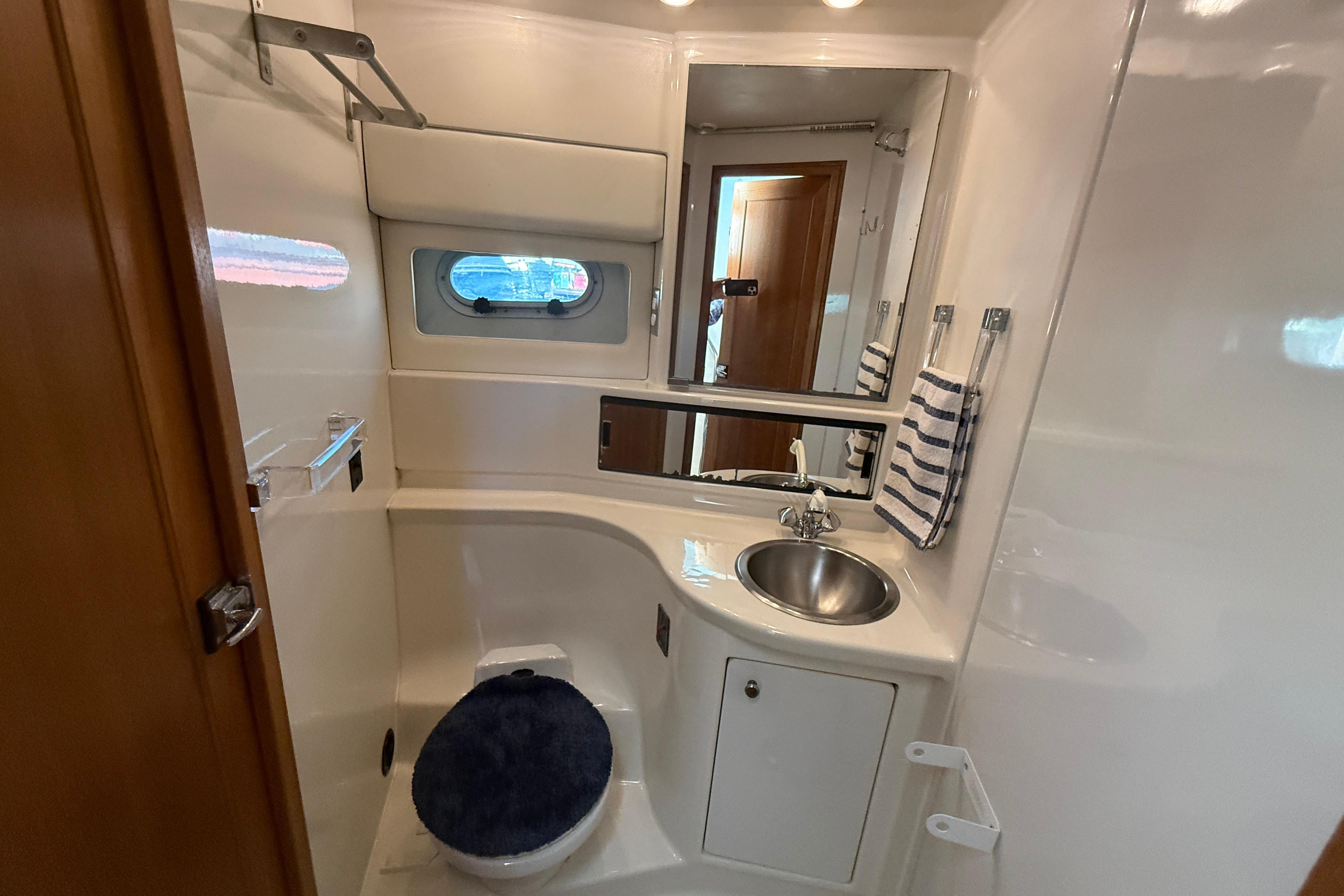 Bathroom interior of 1997 Bayliner 3988 Command Bridge Motoryacht, featuring sink and porthole window.