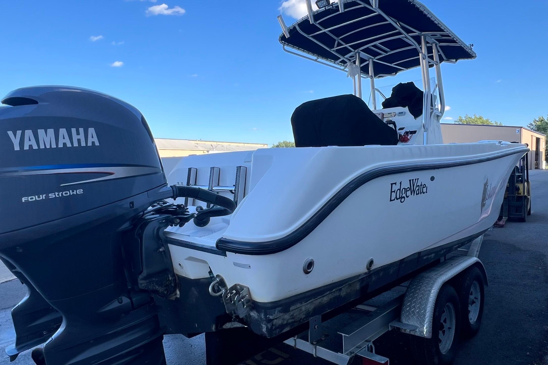 2006 Edgewater 245CC boat with Yamaha four-stroke engine on trailer, under clear blue sky.