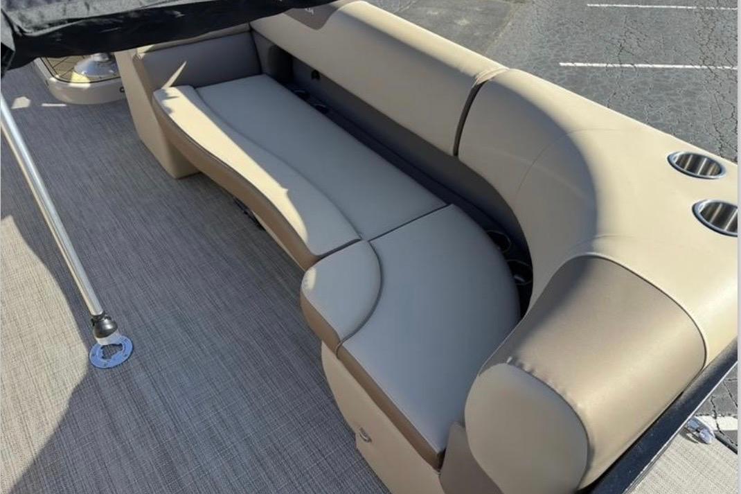 Luxurious seating on 2025 Veranda VR25RC XL pontoon boat, featuring beige upholstery and cup holders.