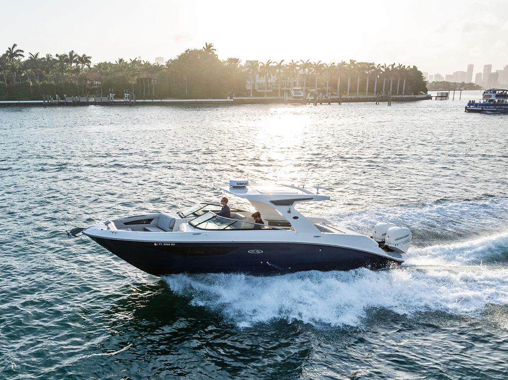 2021 Sea Ray 350 SLX OB cruising on a sunny day, surrounded by scenic waterfront views.