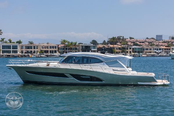 2025 Riviera 645 SUV luxury yacht cruising in a scenic harbor.