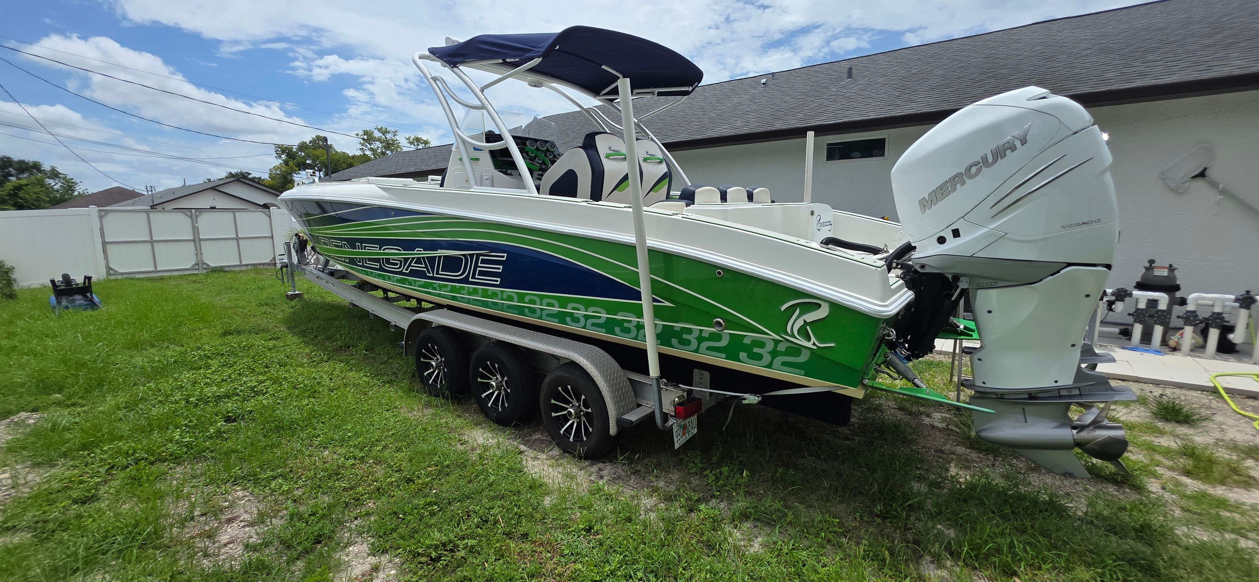 2013 Renegade 32 FT boat with Mercury engine, green and white design.