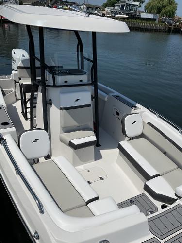 2025 Starcraft SVX 211 OB CC boat with seating, docked on calm water.
