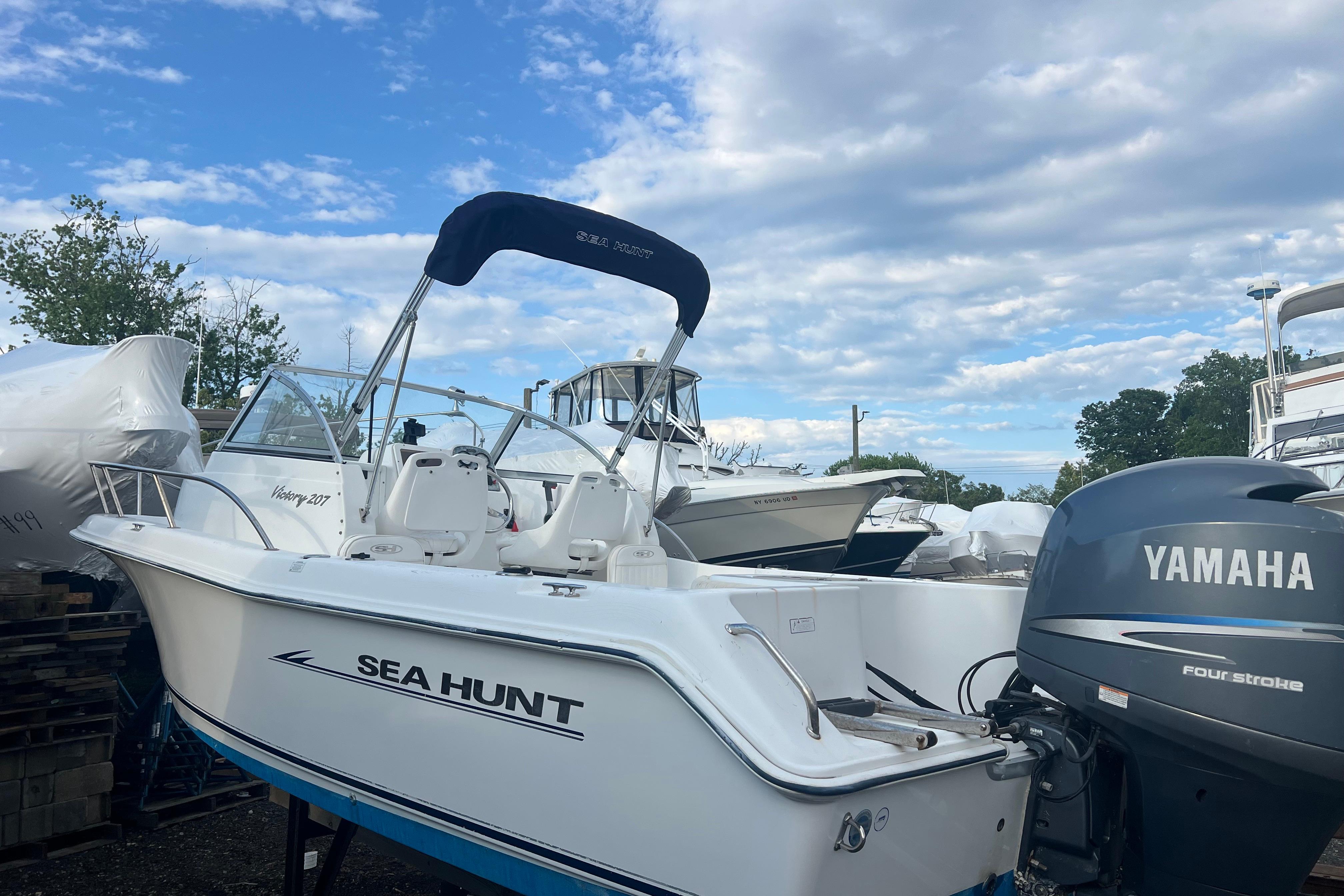 2008 Sea Hunt Victory 207 boat with Yamaha engine, parked outdoors under a blue sky.