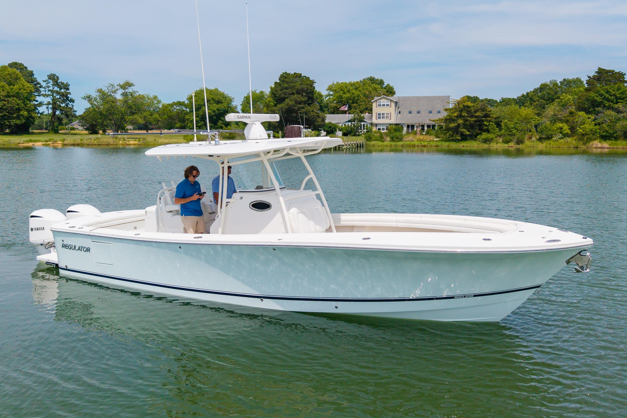 2019 Regulator 31 boat on calm water with lush green shoreline in the background.