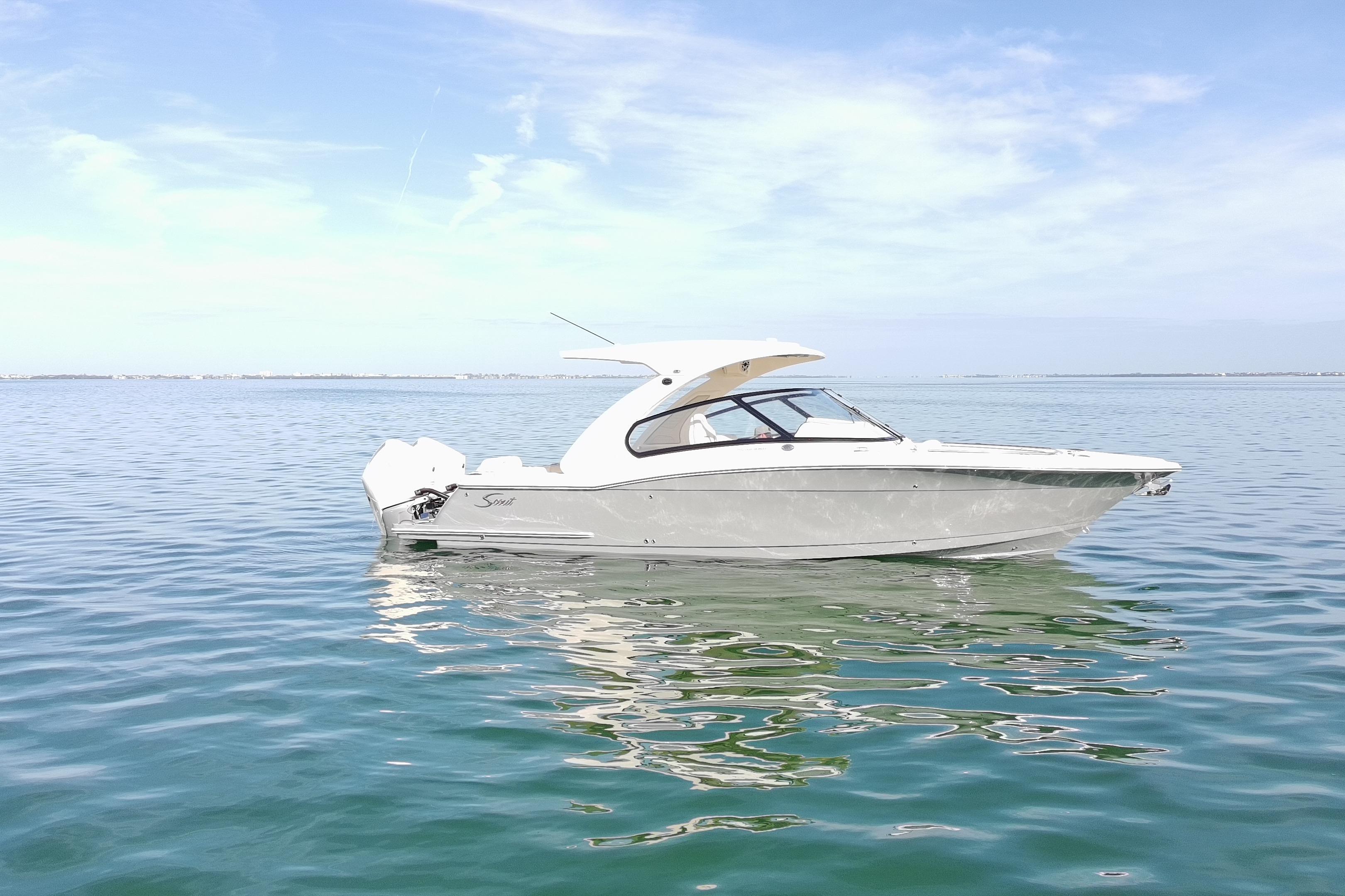 2027 Scout 288 Dorado boat on calm water under clear blue sky.