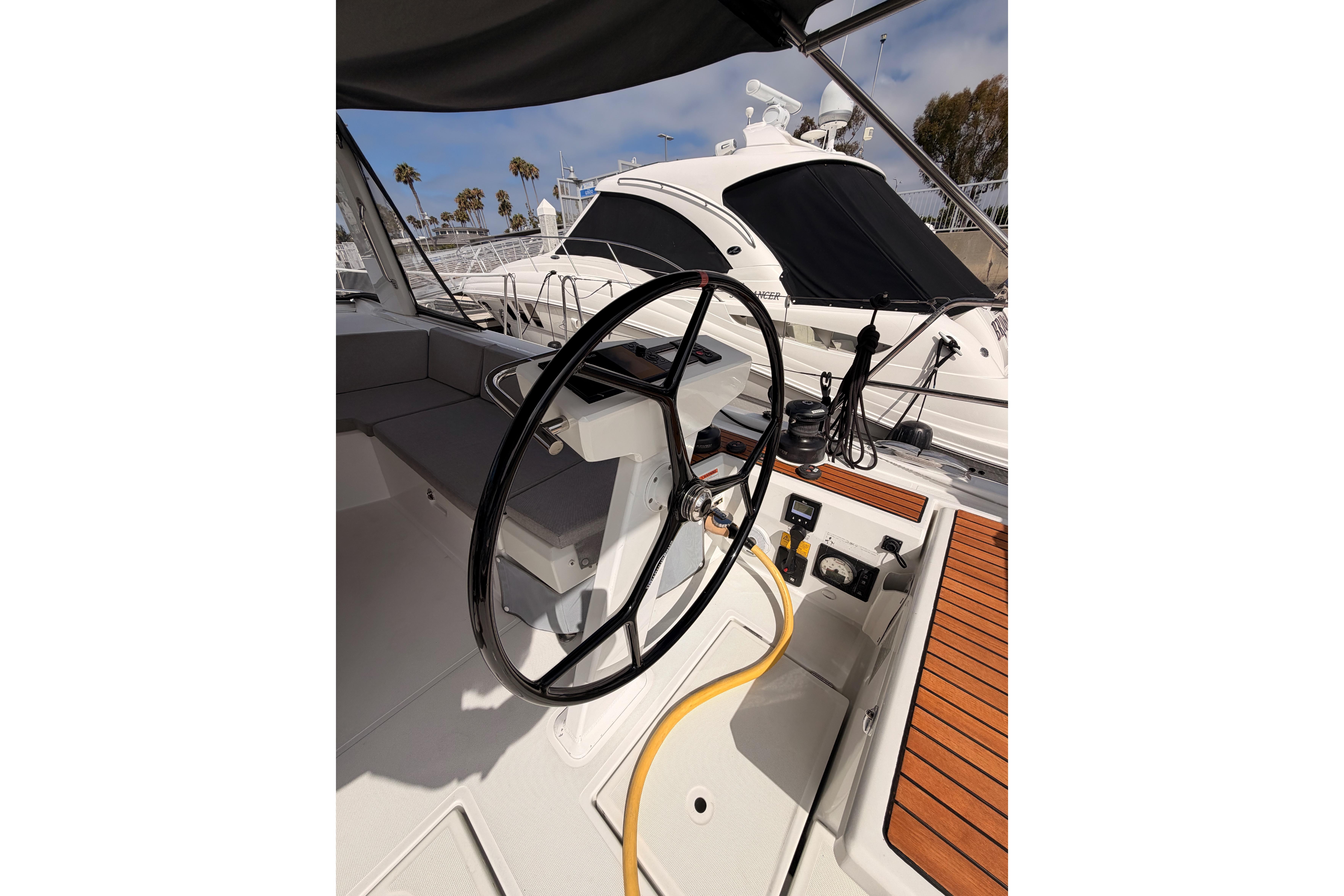 Cockpit of 2020 Beneteau Oceanis 46.1 sailboat with steering wheel and teak decking.