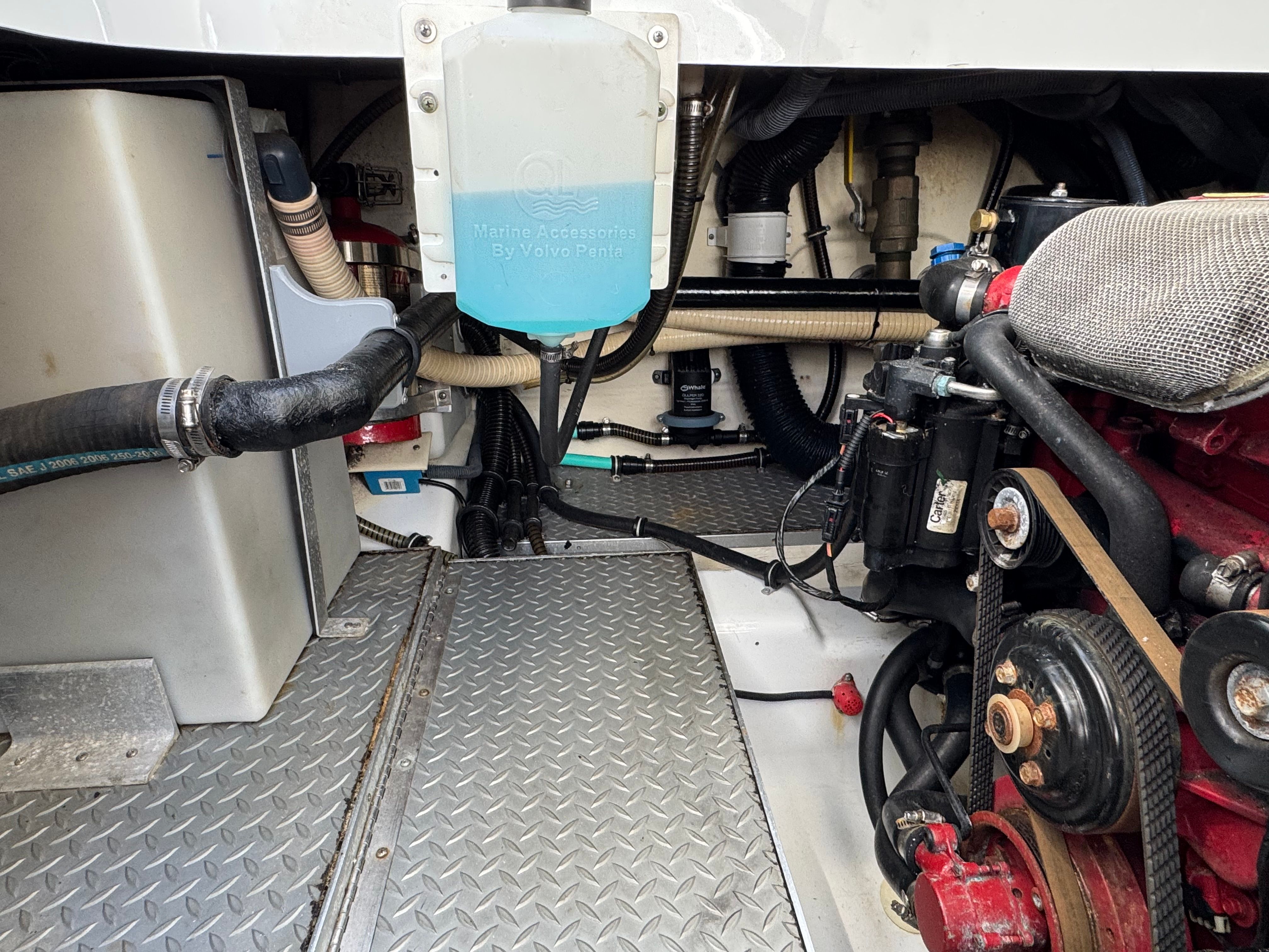 Boat engine compartment with hoses and machinery.
