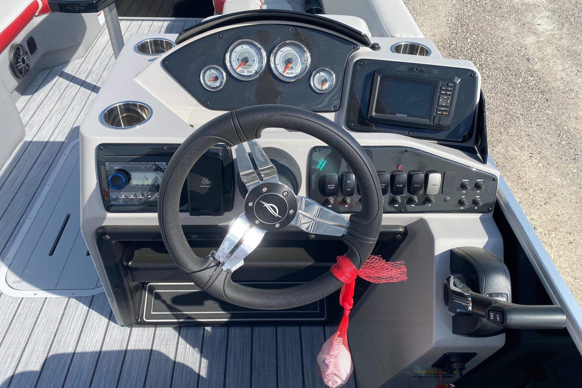 2026 SunCatcher Select 322RC boat dashboard with steering wheel, gauges, and controls.