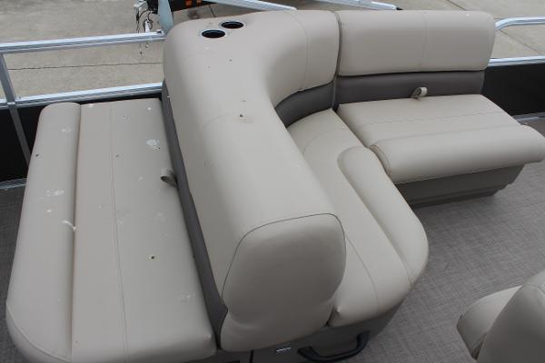 2025 Sun Tracker Party Barge 18 DLX pontoon boat seating area with beige upholstery.