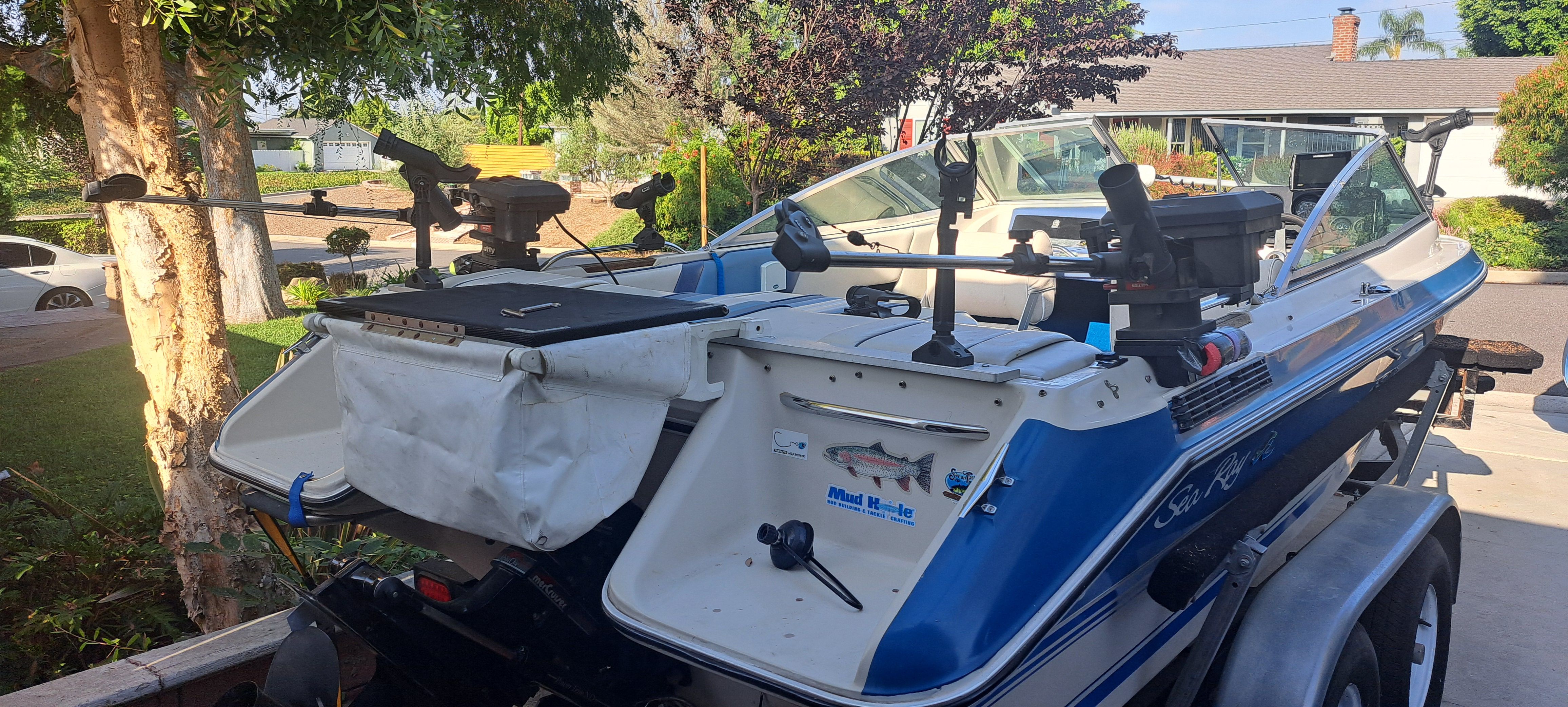 1988 Sea Ray Sevville boat parked in garden with fishing rod holders.