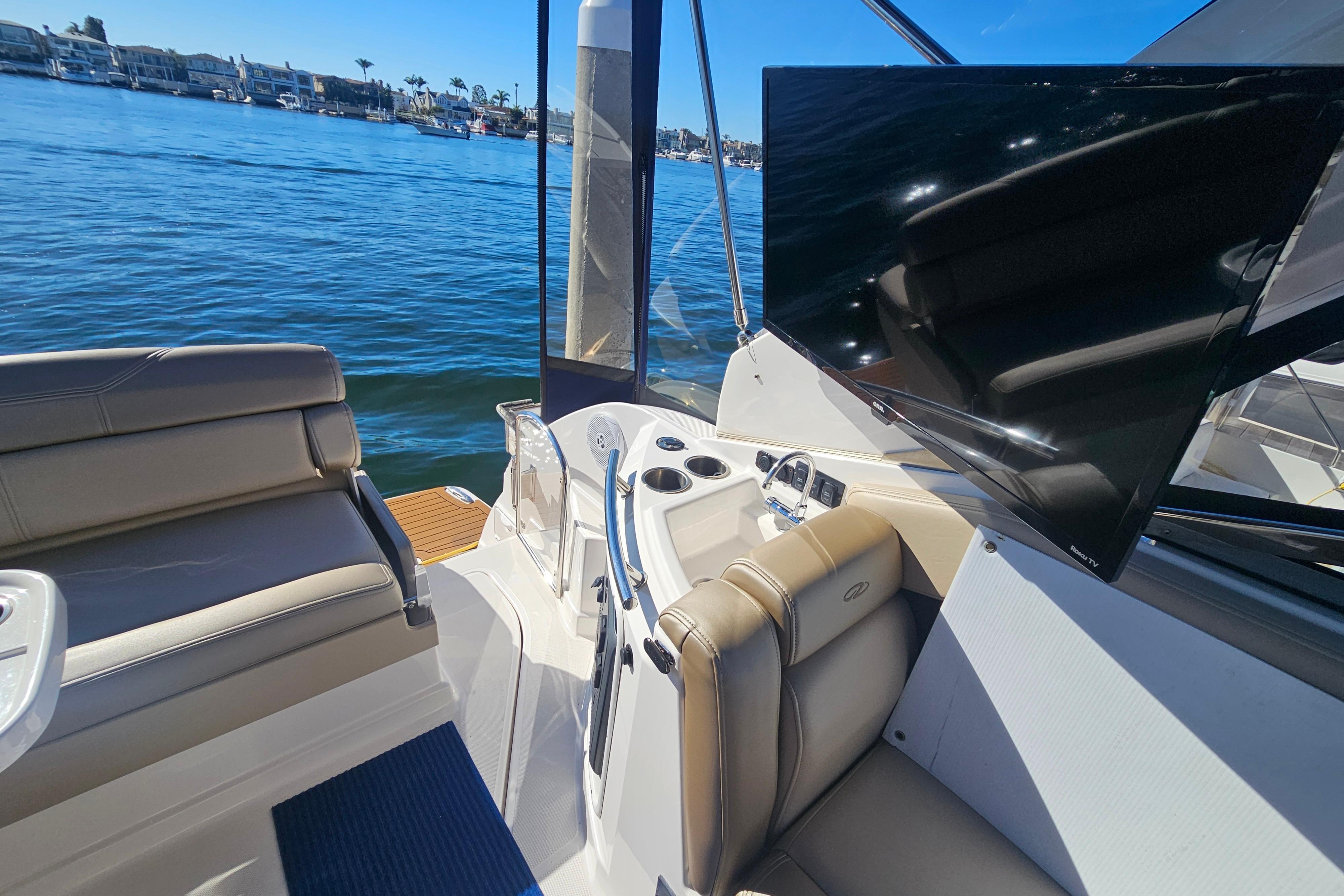 2013 Regal 28 Express boat interior with seating, TV, and water view.