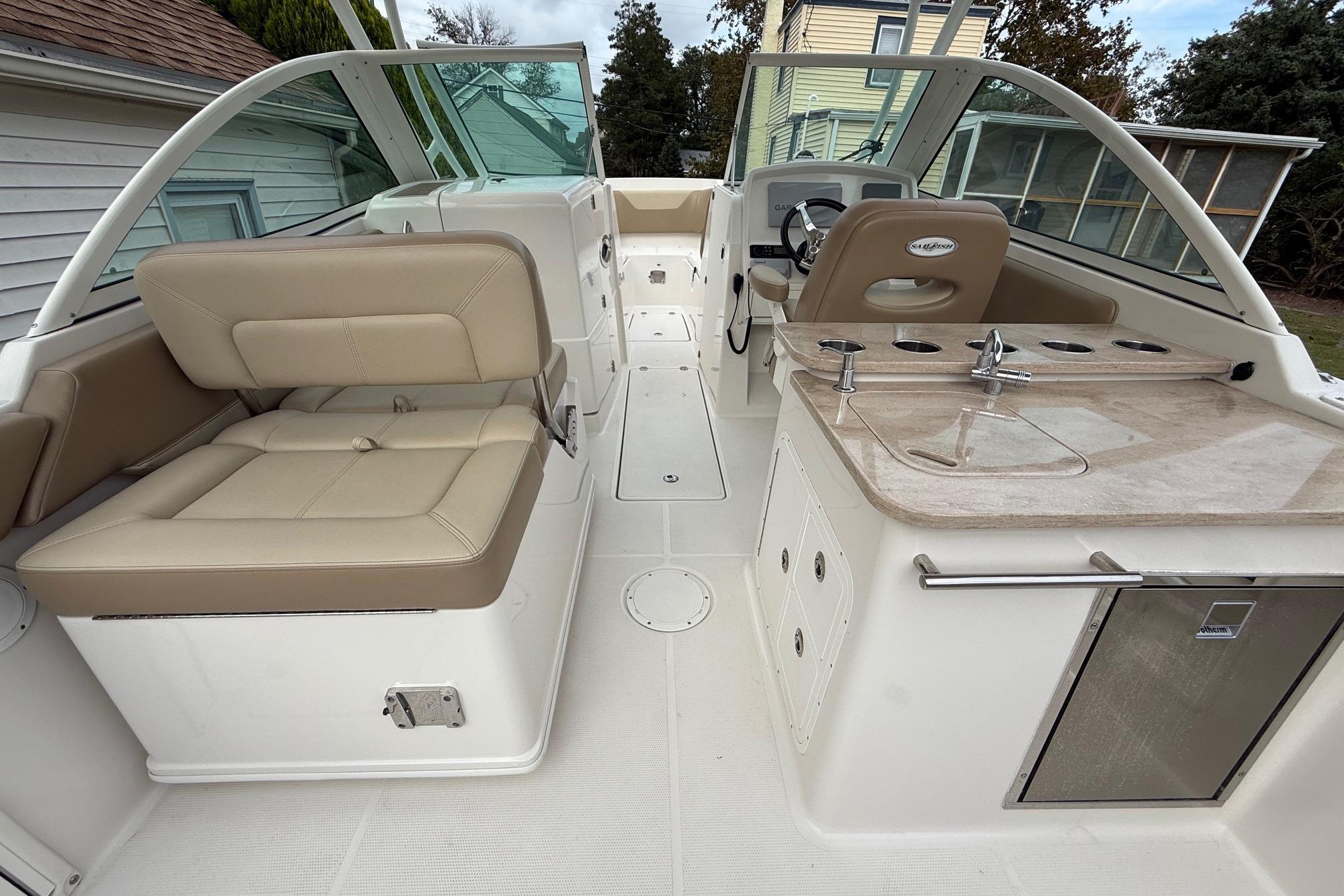 2019 Sailfish 275 DC boat interior with beige seating and kitchenette area.