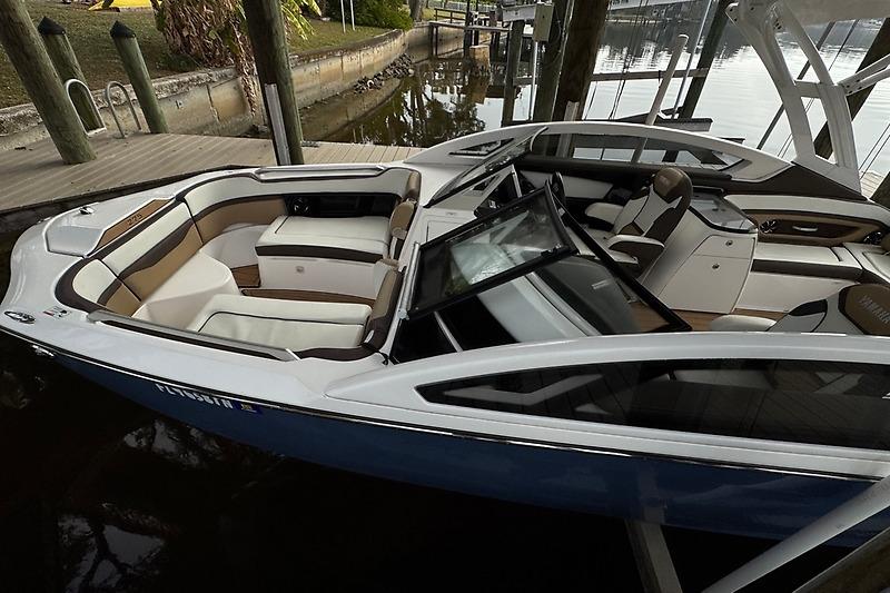 2023 Yamaha 275SDX boat with spacious seating docked by a wooden pier.