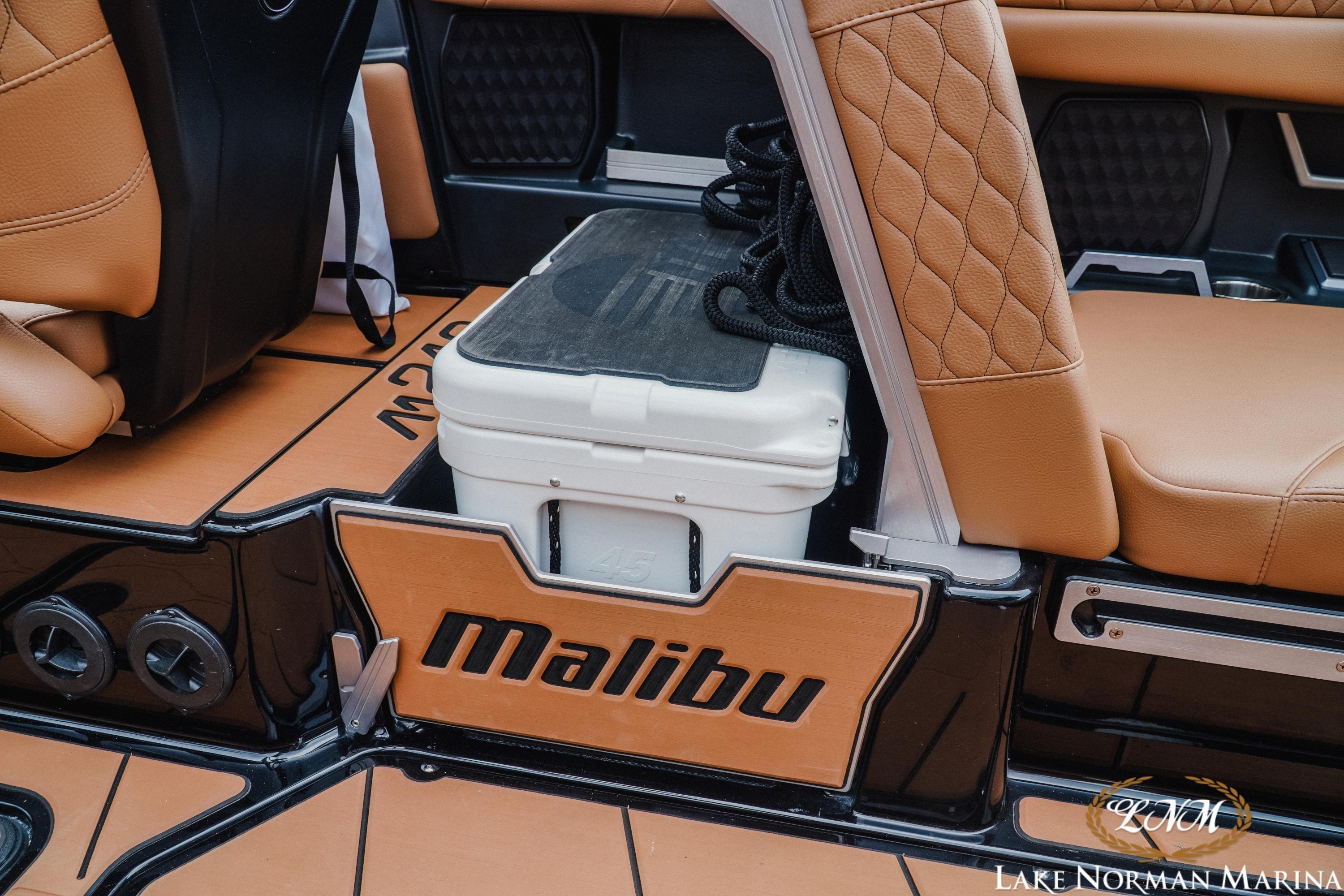 2021 Malibu M240 boat interior with tan leather seats and cooler storage.