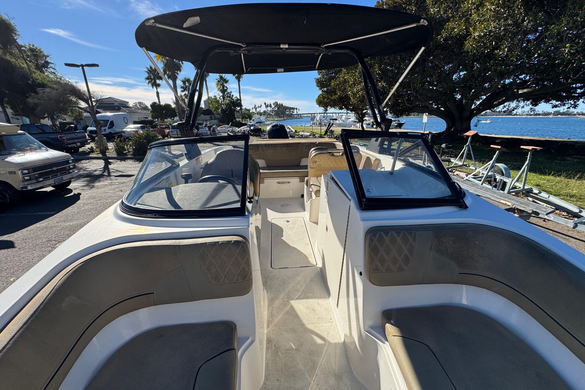 2022 Bayliner VR6 Bowrider OB with spacious seating, docked near a scenic waterfront.
