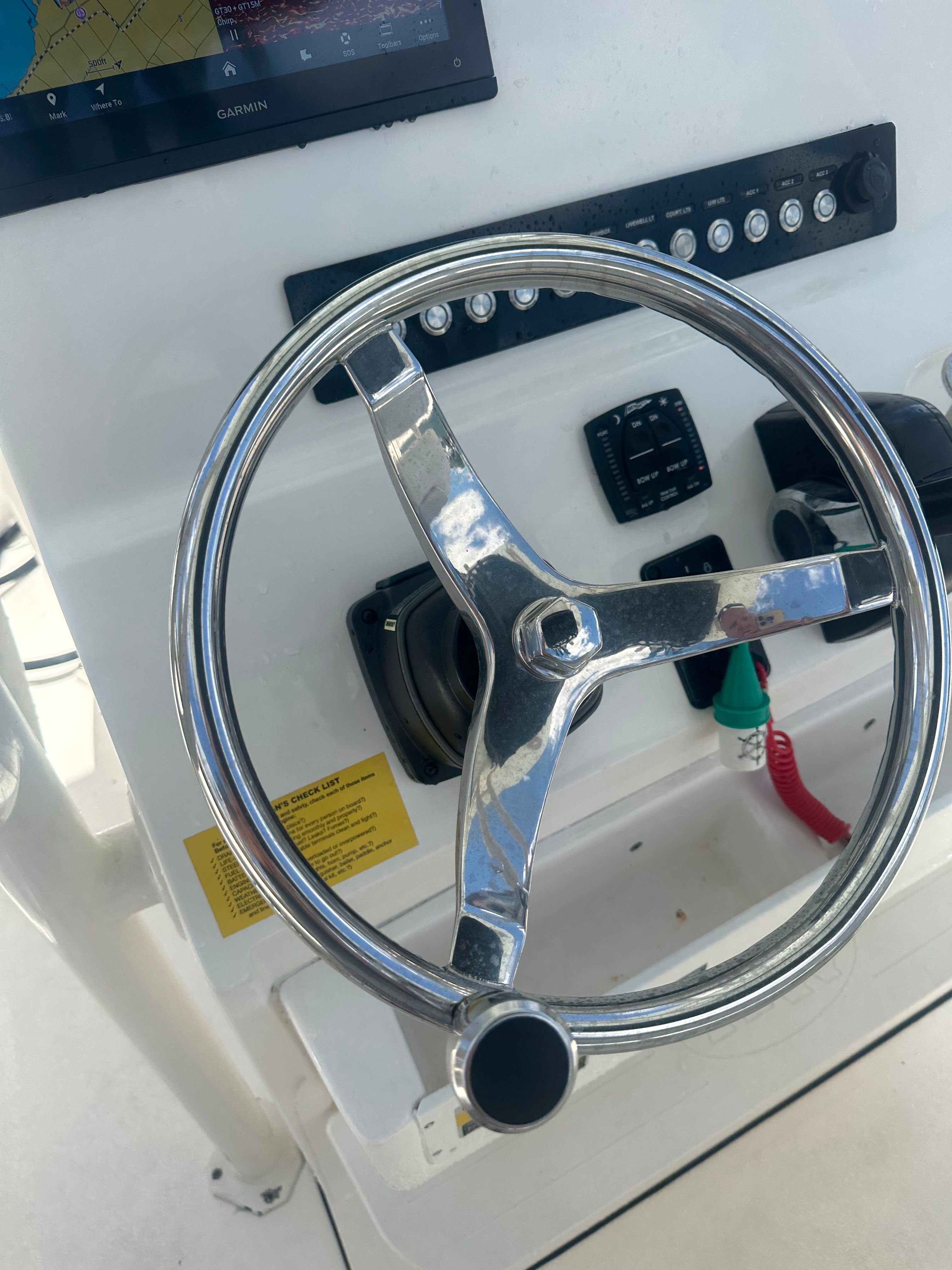 Close-up of a shiny boat steering wheel with instrument panel.