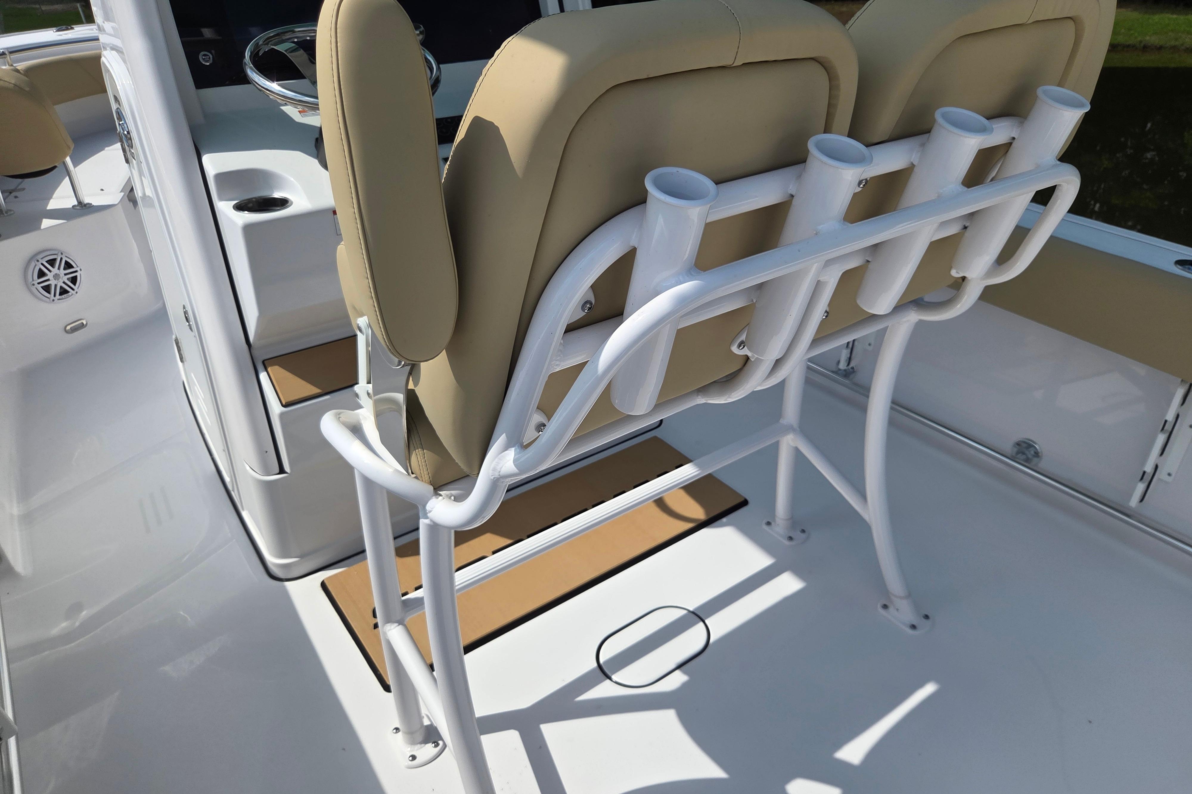 2026 Sportsman Open 232 Center Console boat interior with beige seating and rod holders.